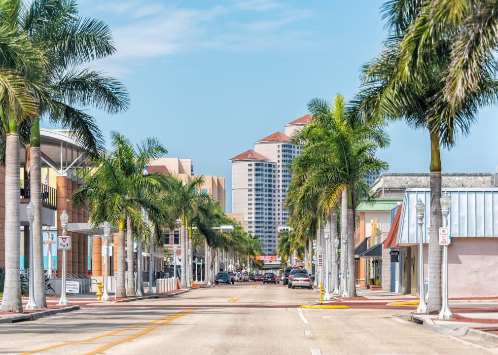 A Fort Myers city street lined with palm trees on a sunny day.