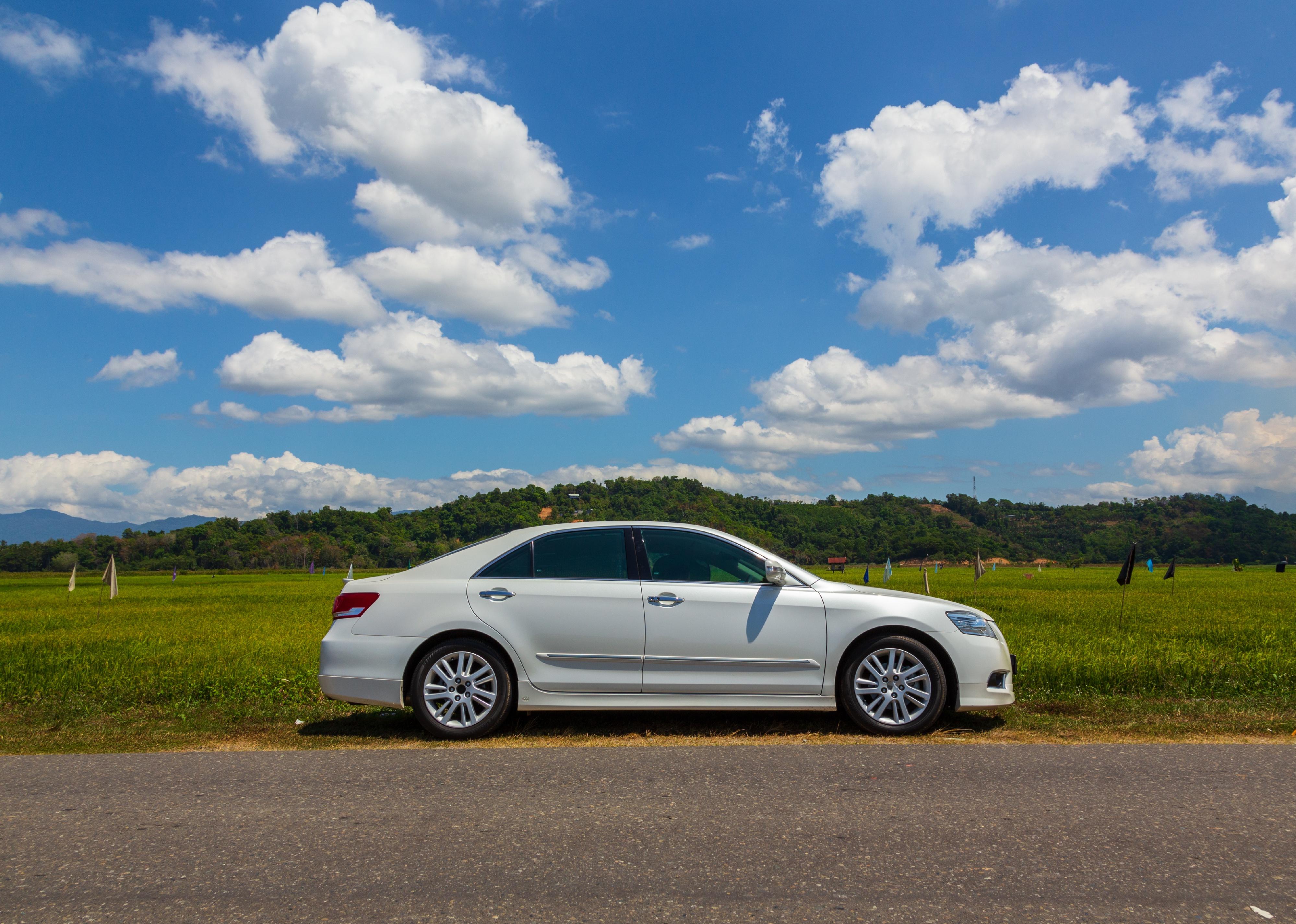Toyota Camry with beautiful white cloud and blue sky landscape view