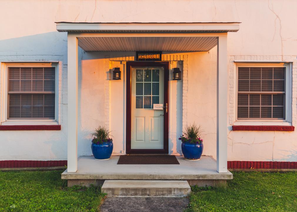 Front porch of white house with potted plants