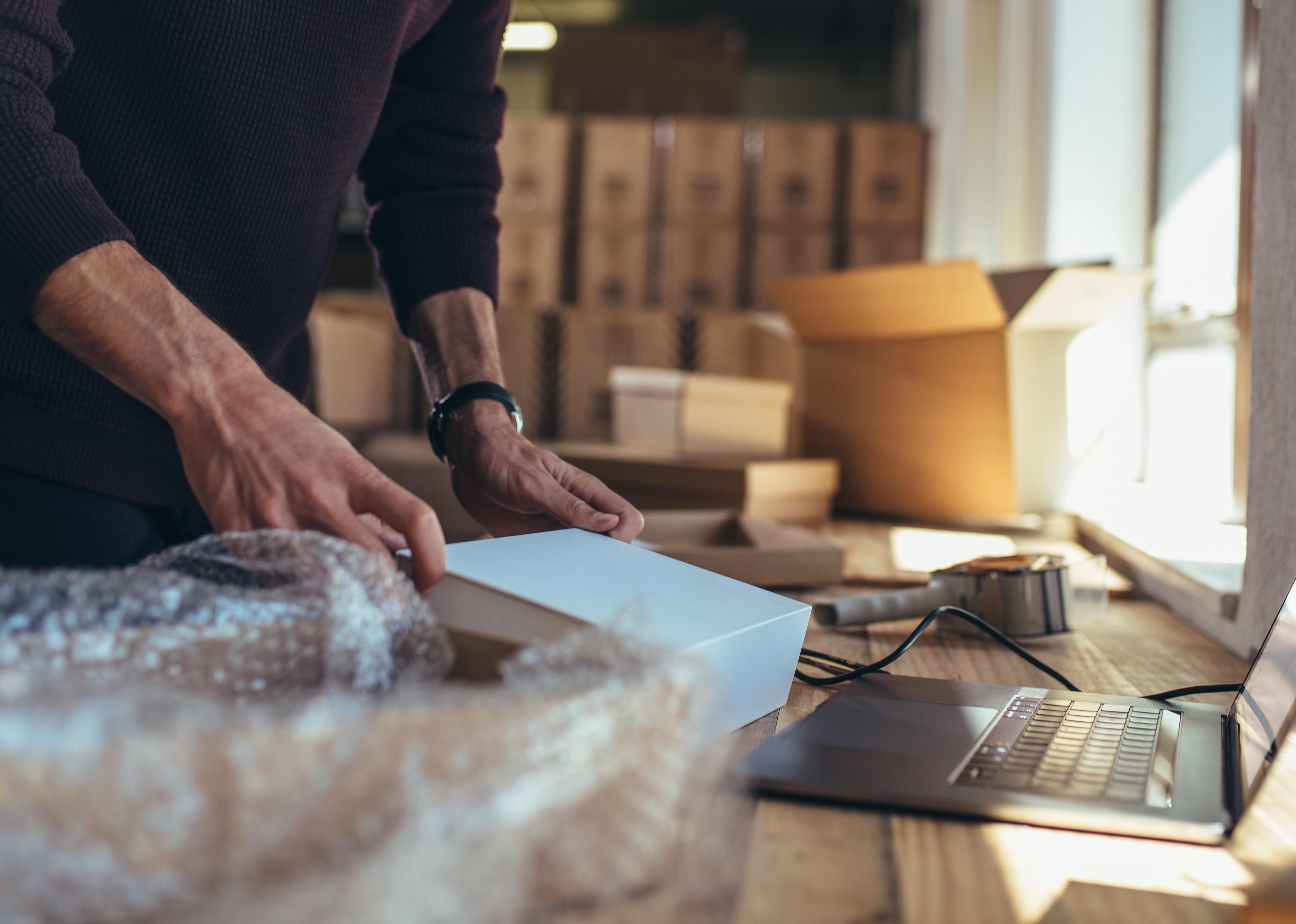 Small business owner packing in the cardbox at workplace.
