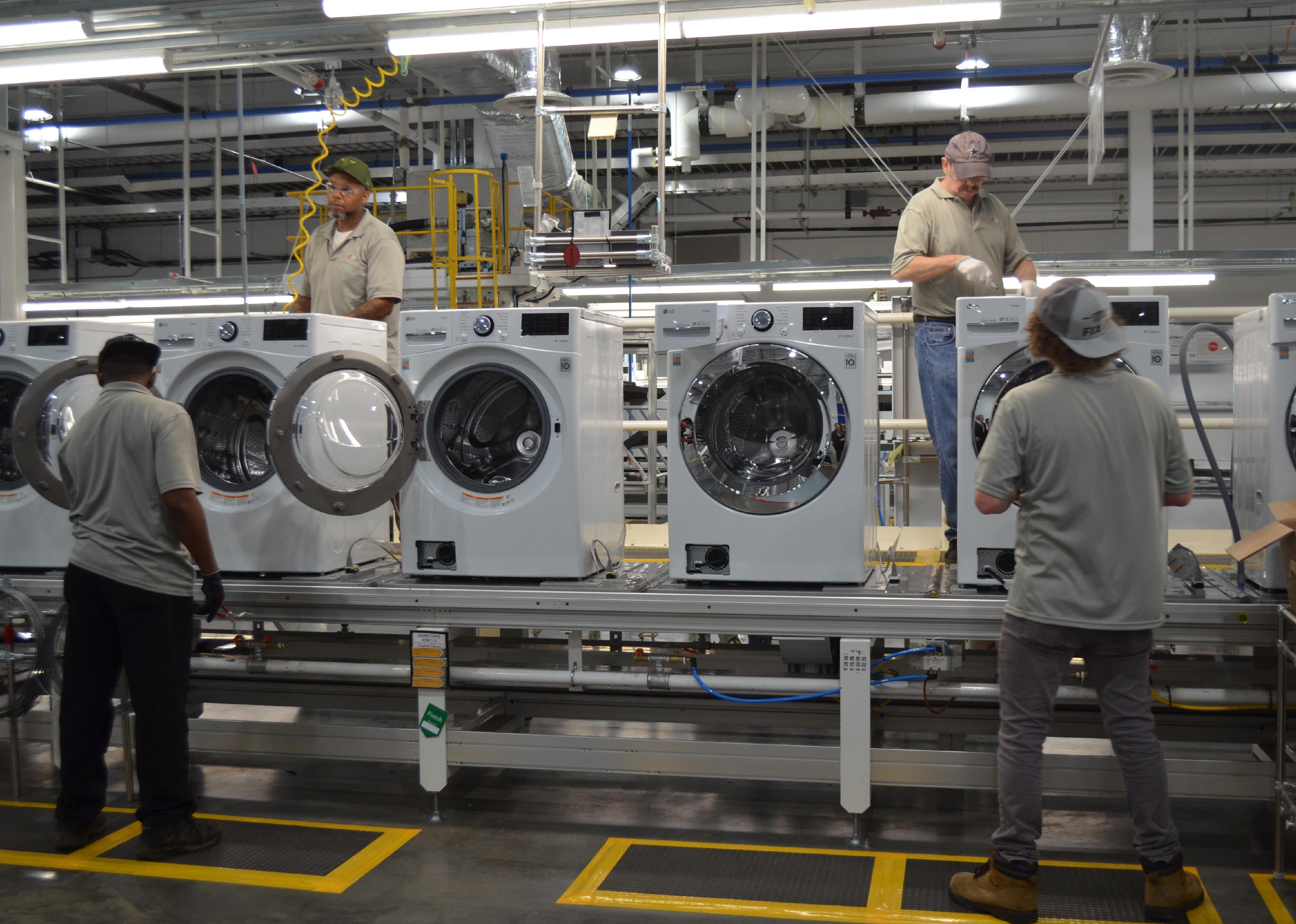 Employees work on LG washing machines