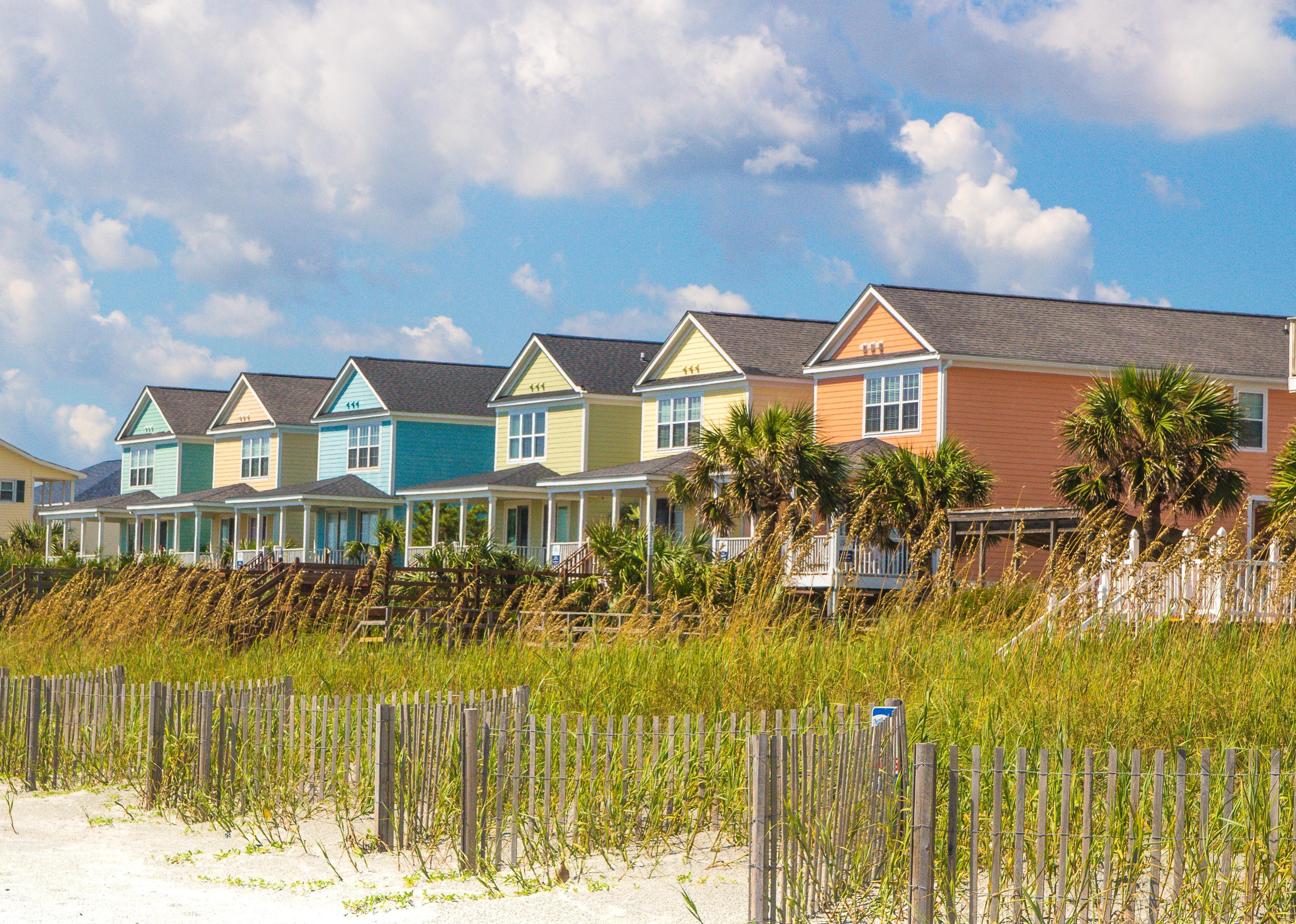 Sand dunes and colorful beach front homes.