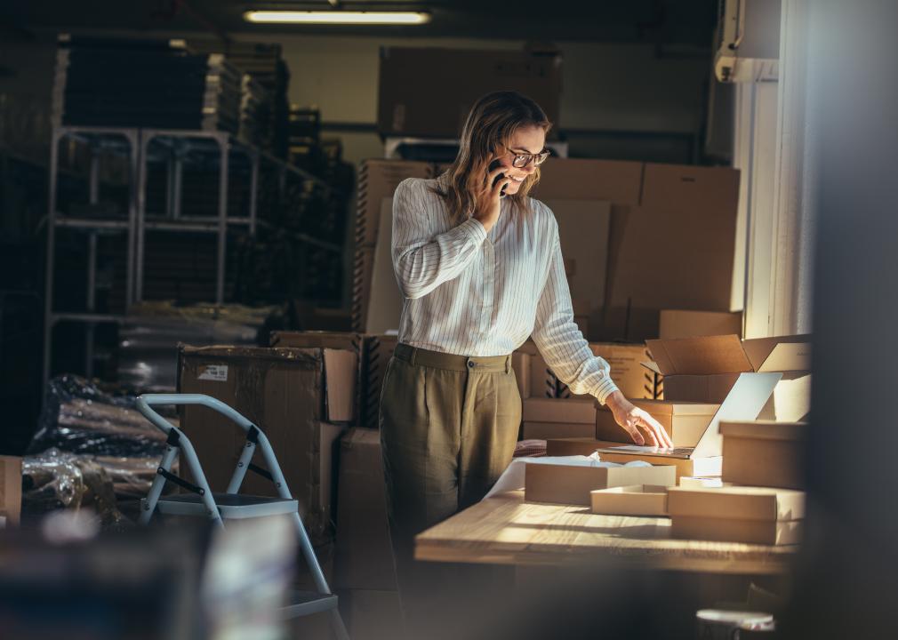 Female online seller on the phone in warehouse