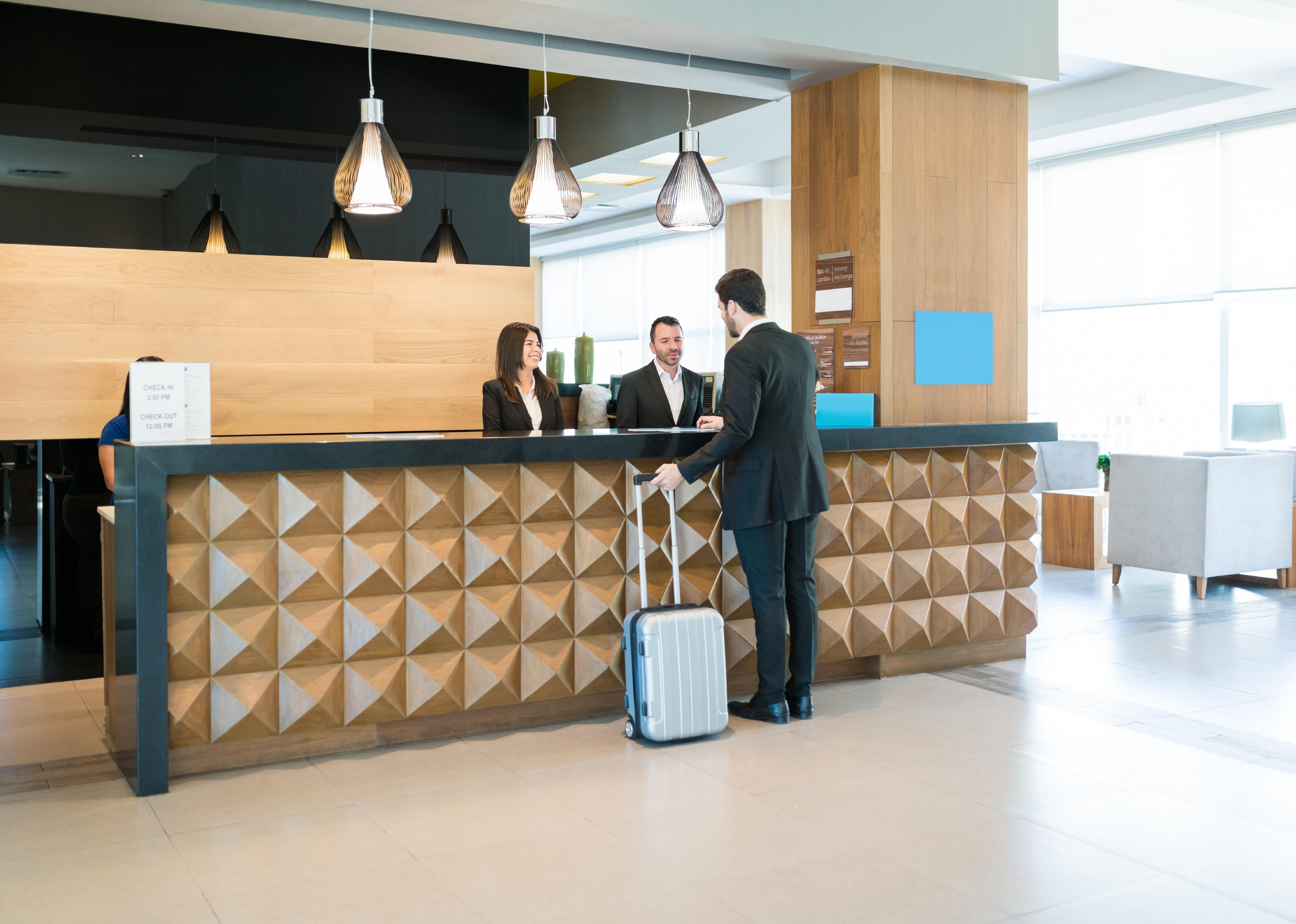 Businessman at front desk of a hotel lobby.