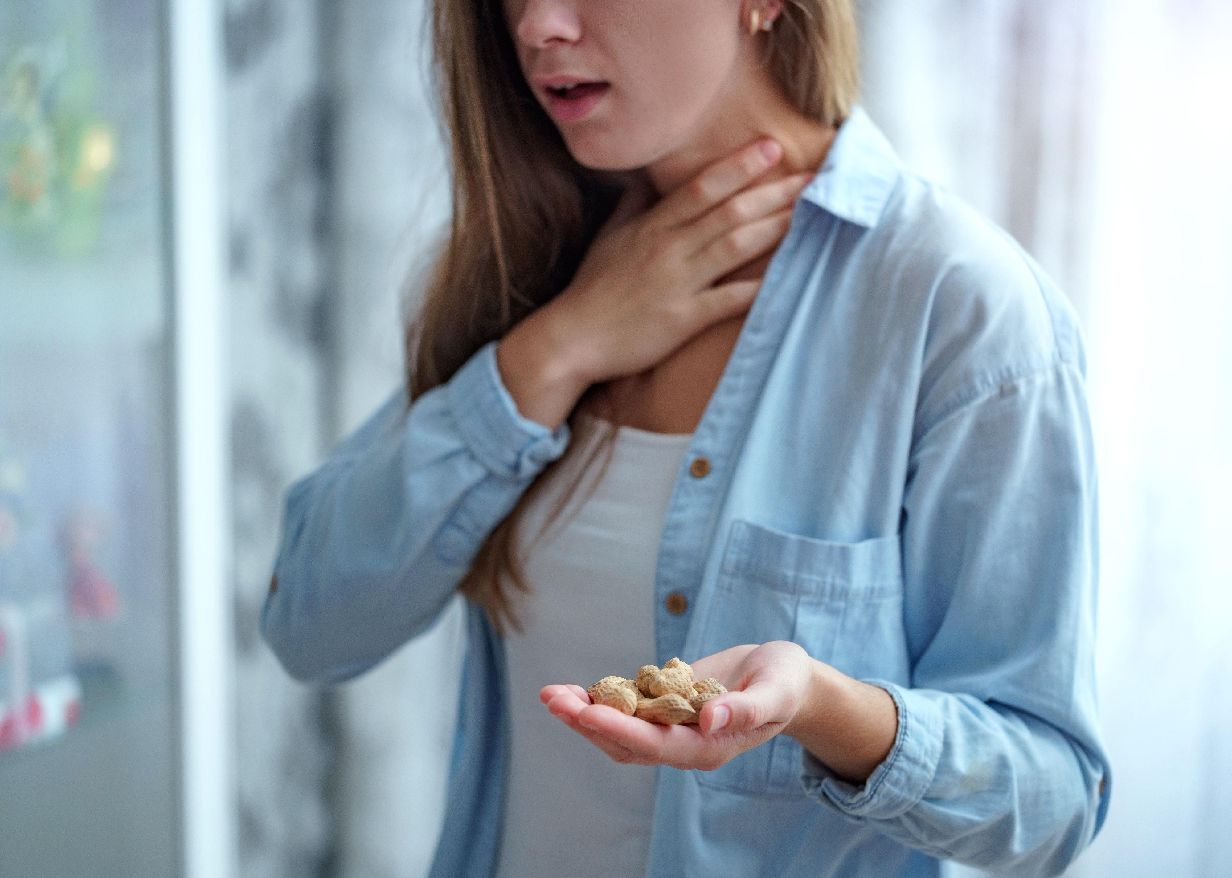 Young person with hand over throat from choking.