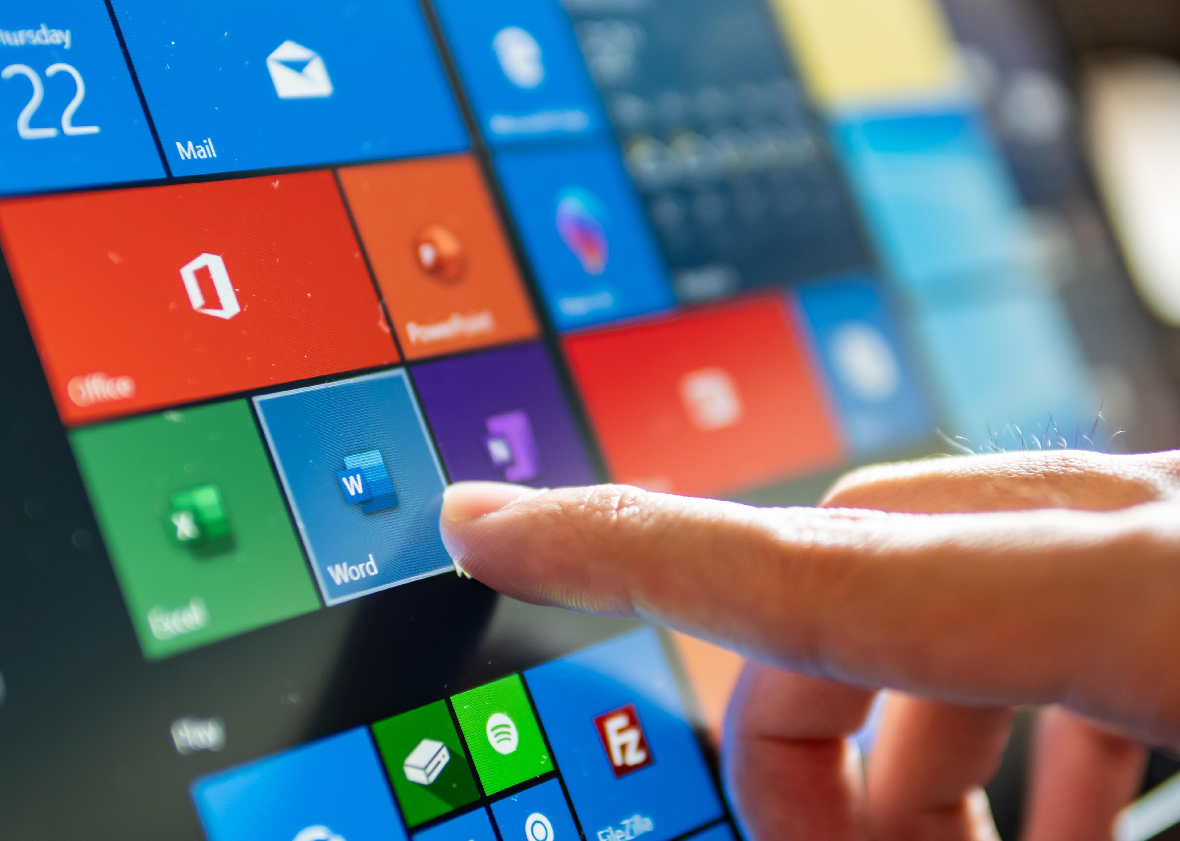 Computer user touching on Microsoft word icon to open the program.