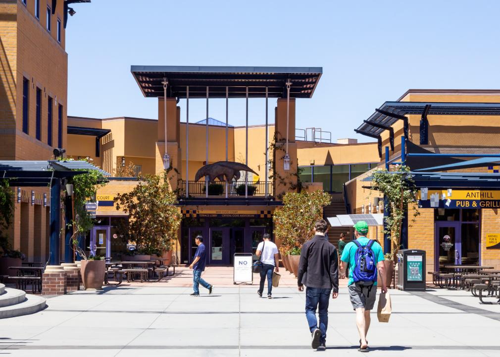 Students walk towards the Student Center on the UCI Campus