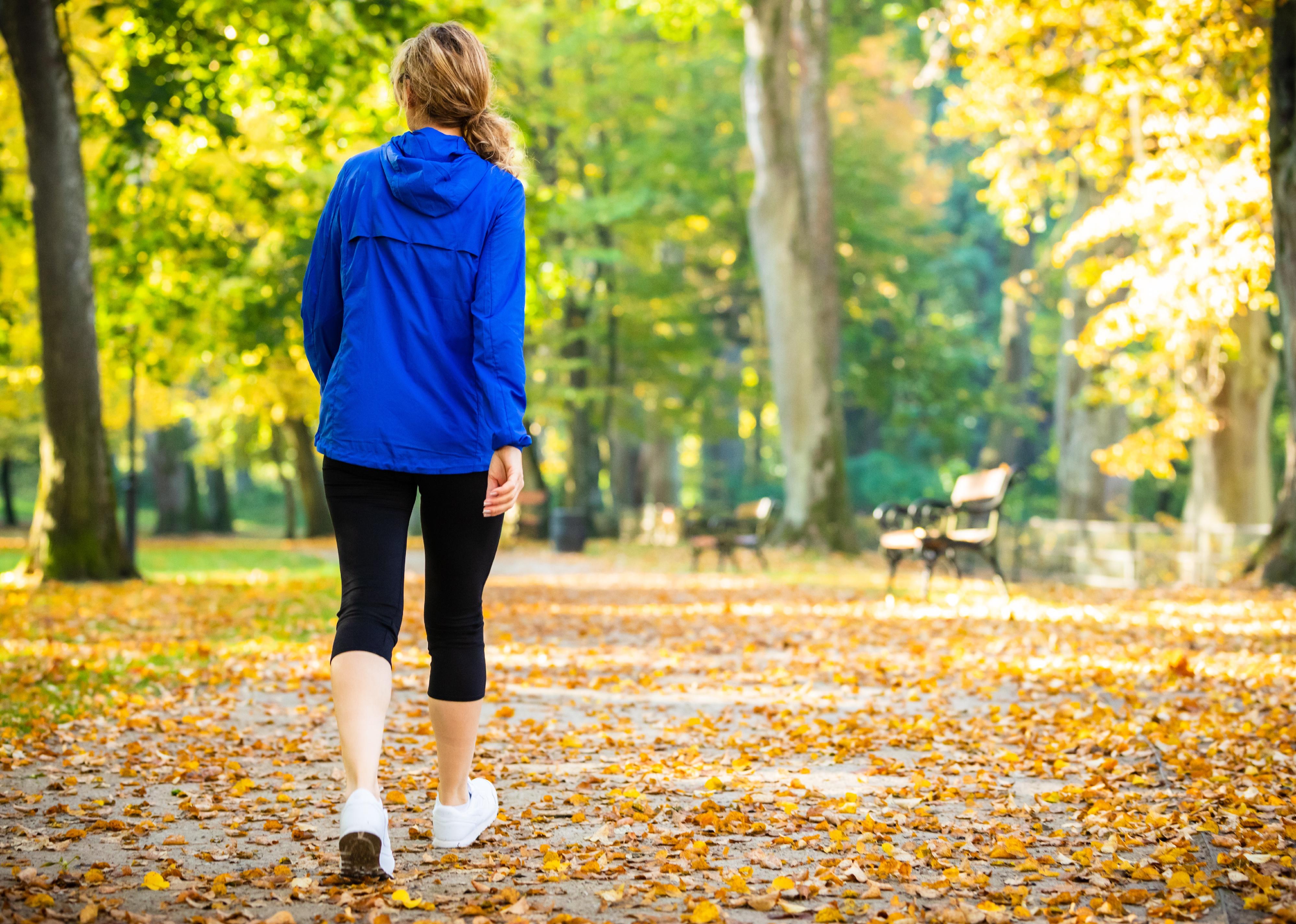 Middle-aged woman walking in city park.
