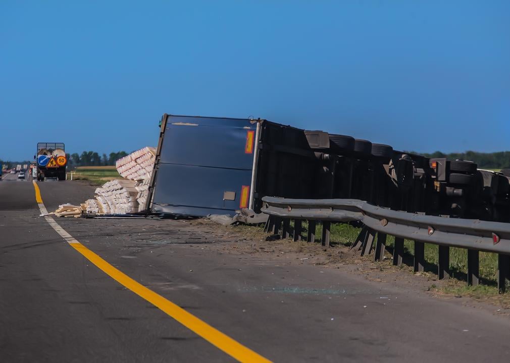 Overturned truck semi-trailer with cargo spilling out