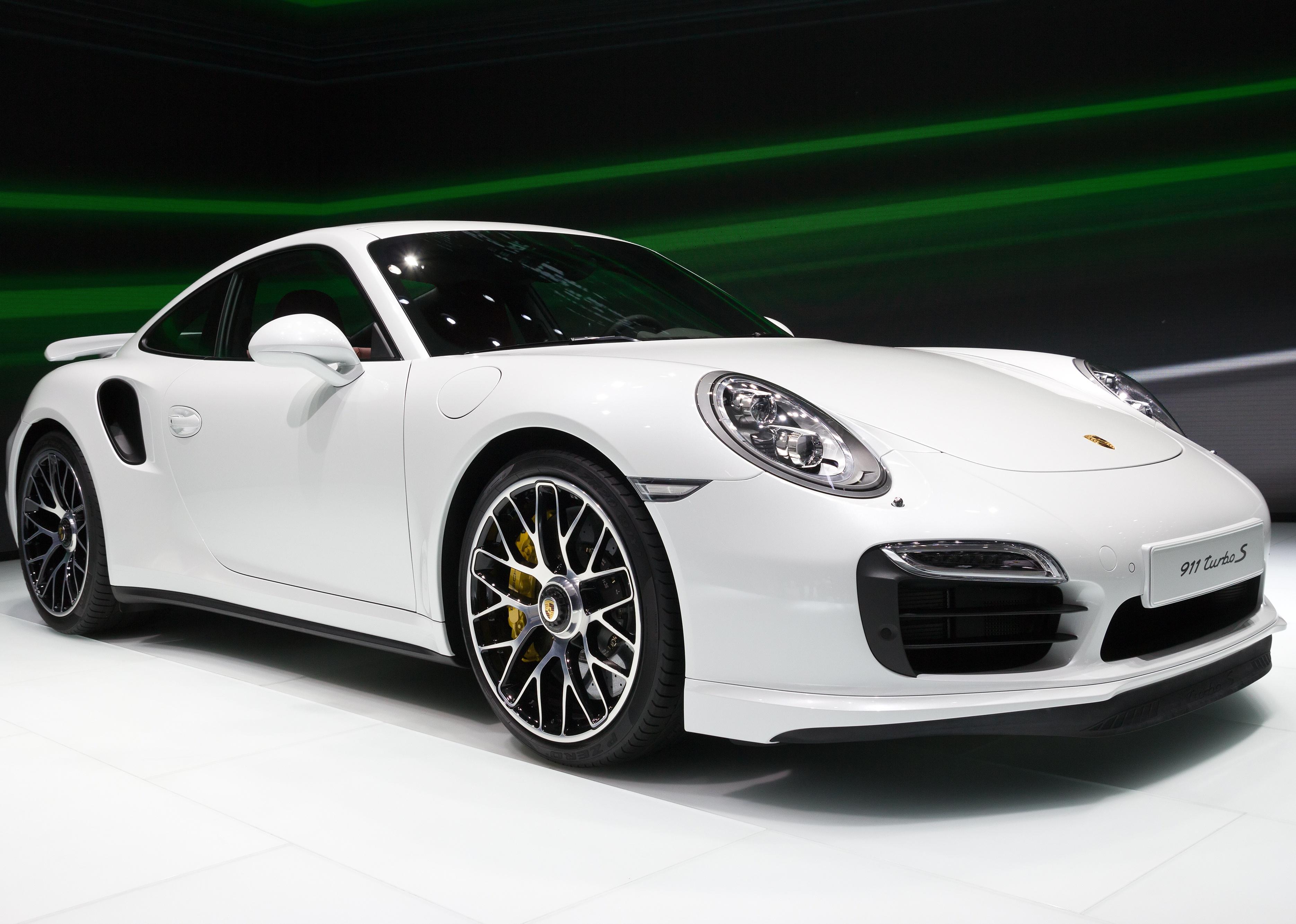 A white Porsche 911 Turbo S at a motor show.