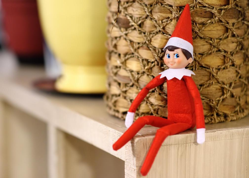 Close up detail of the Elf on the Shelf toy on a bookshelf.