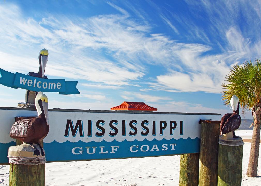 Welcome sign with beach in the background.
