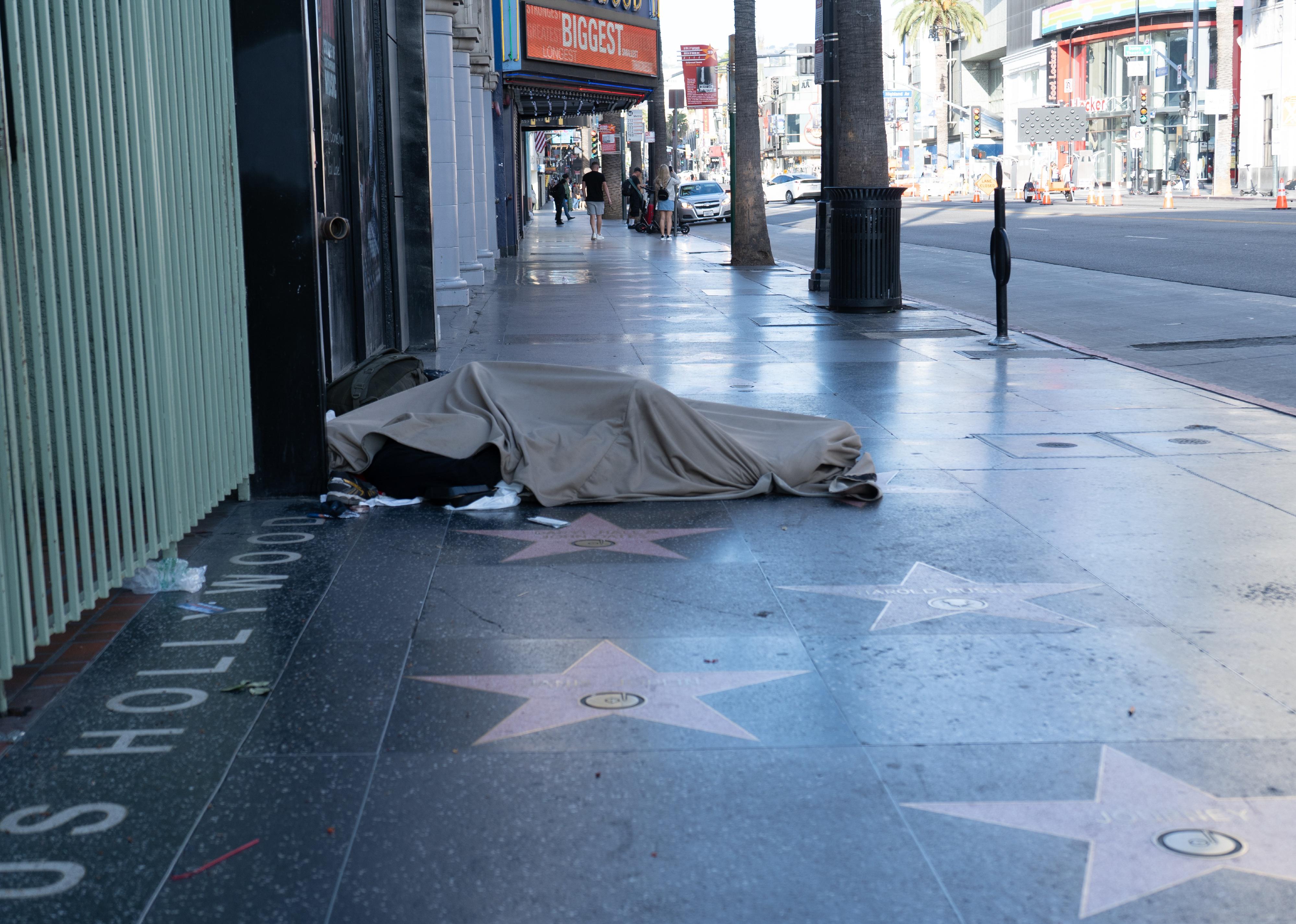 Homeless man sleeping on the Hollywood walk-of-fame.