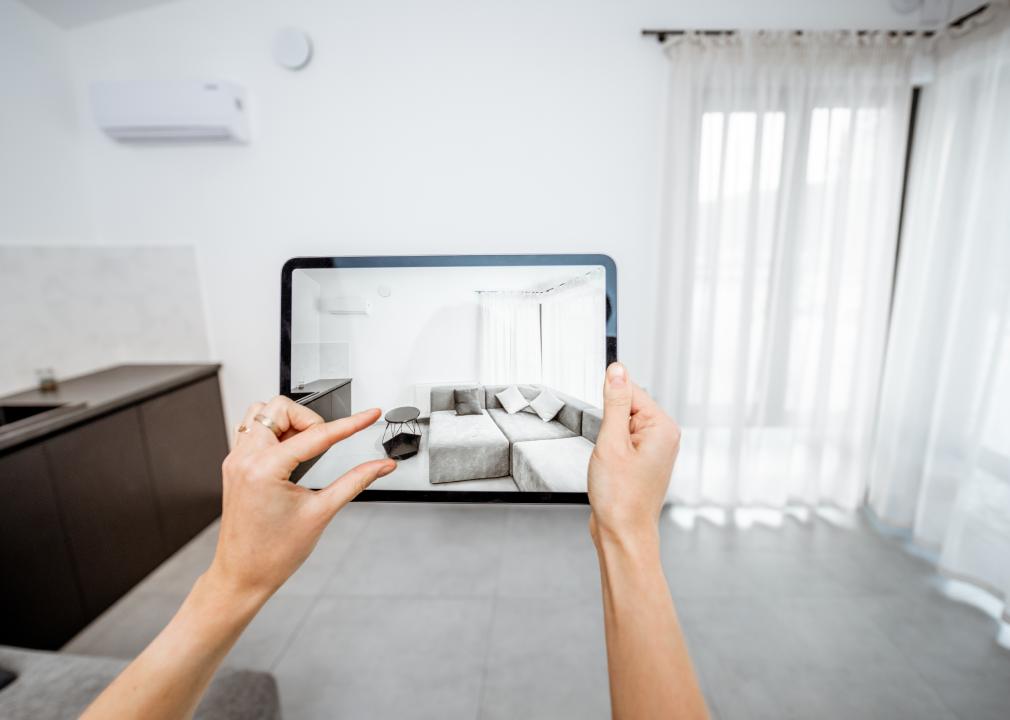 Woman holding iPad with augmented furniture in display