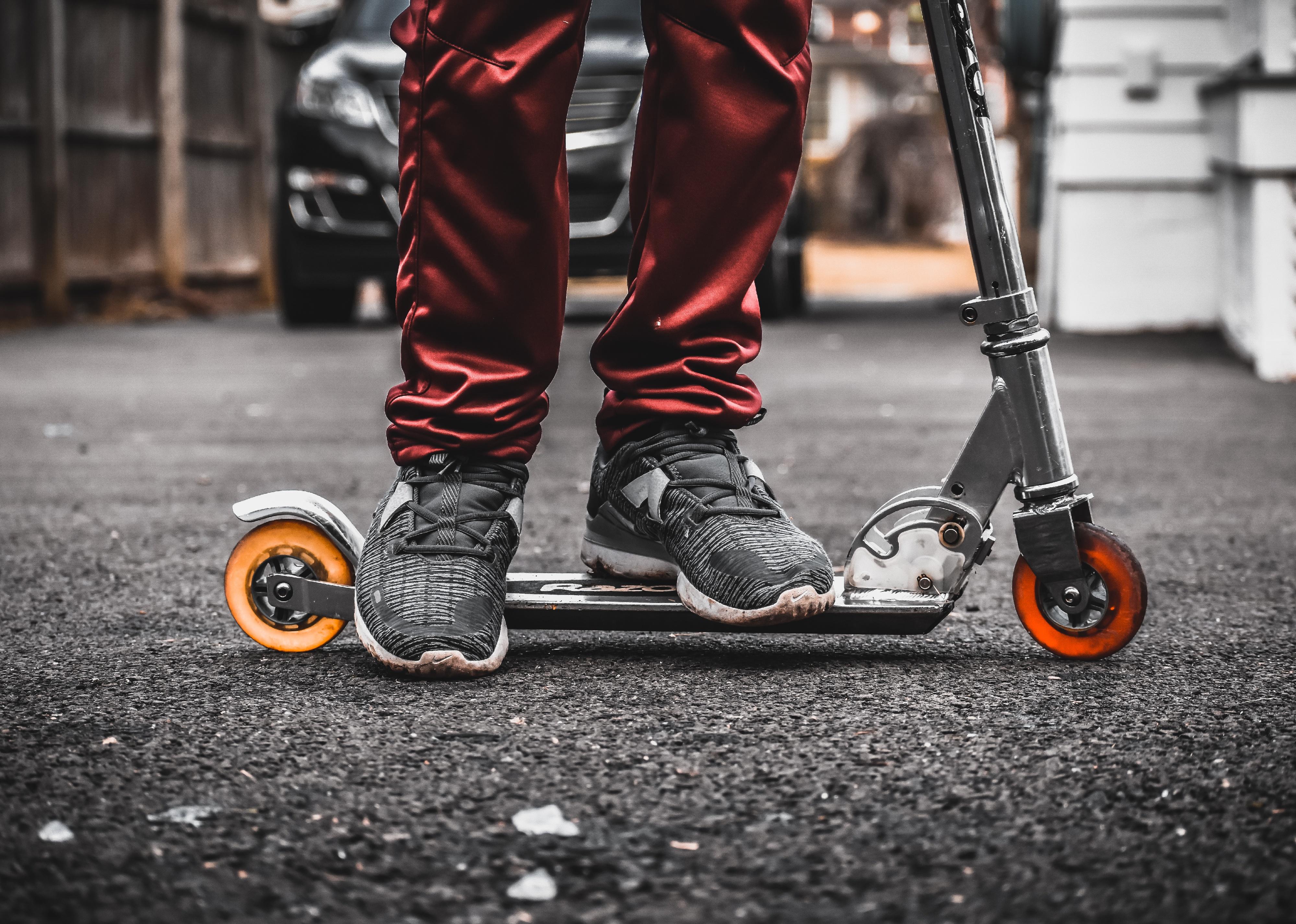 View of person's legs on Razor scooter.