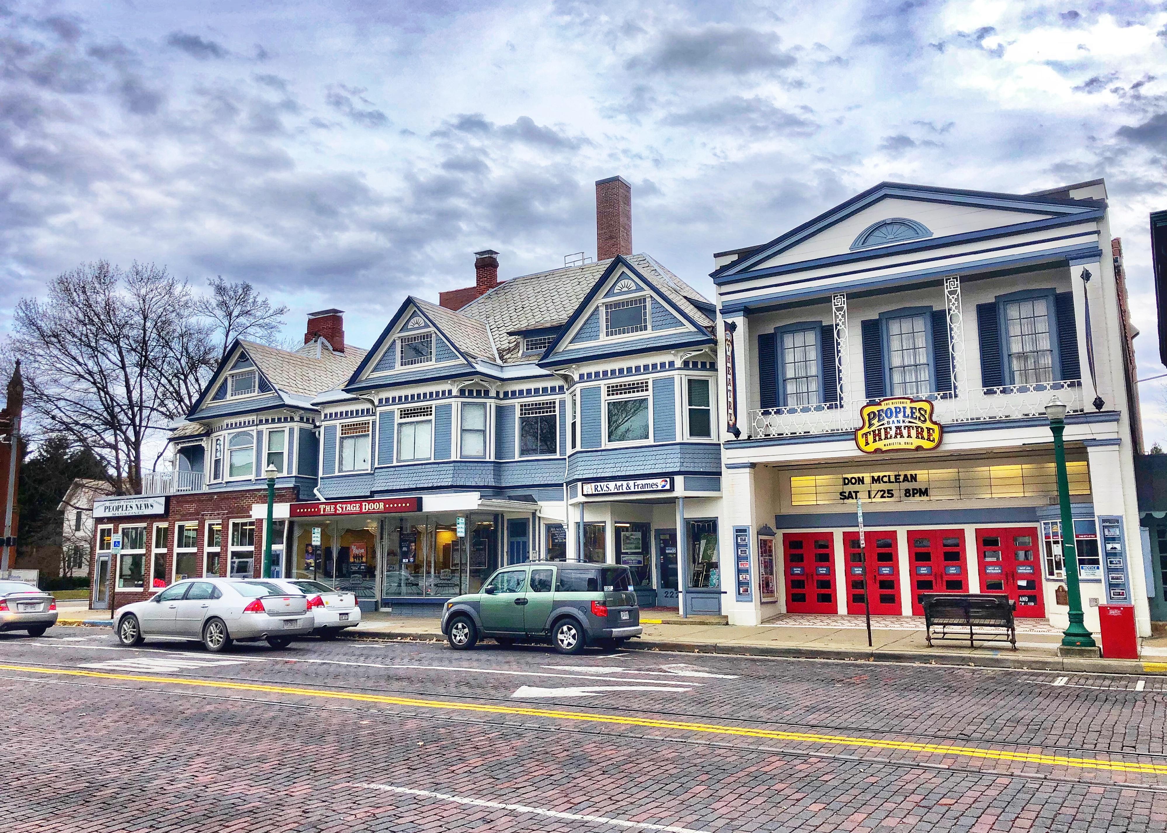 Street view of downtown Marietta with cars parked at curb.