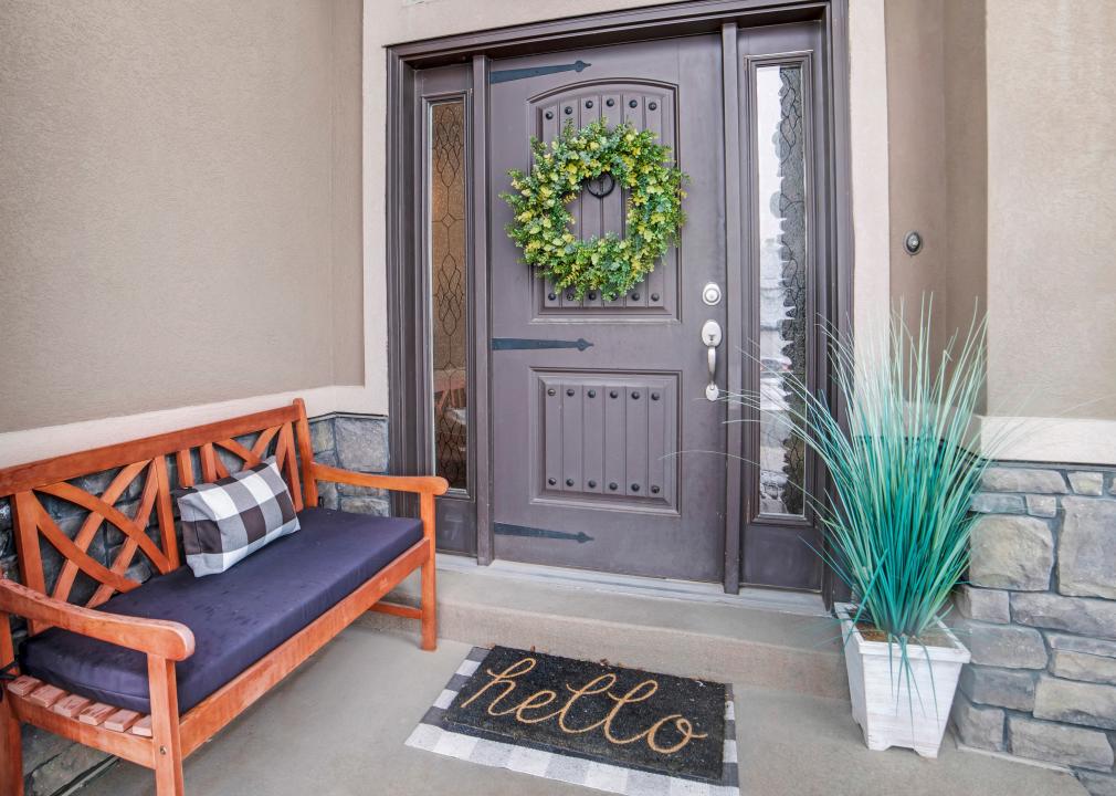 A bench outside the front door of a house.