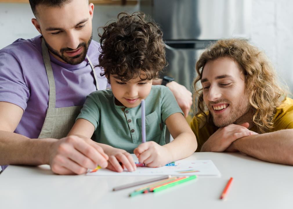 Child drawing with his two fathers