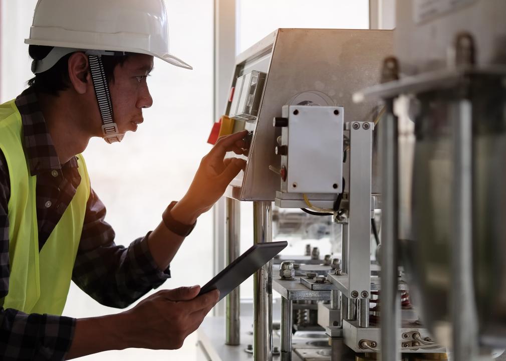 Sideview of technician working with controls on machine