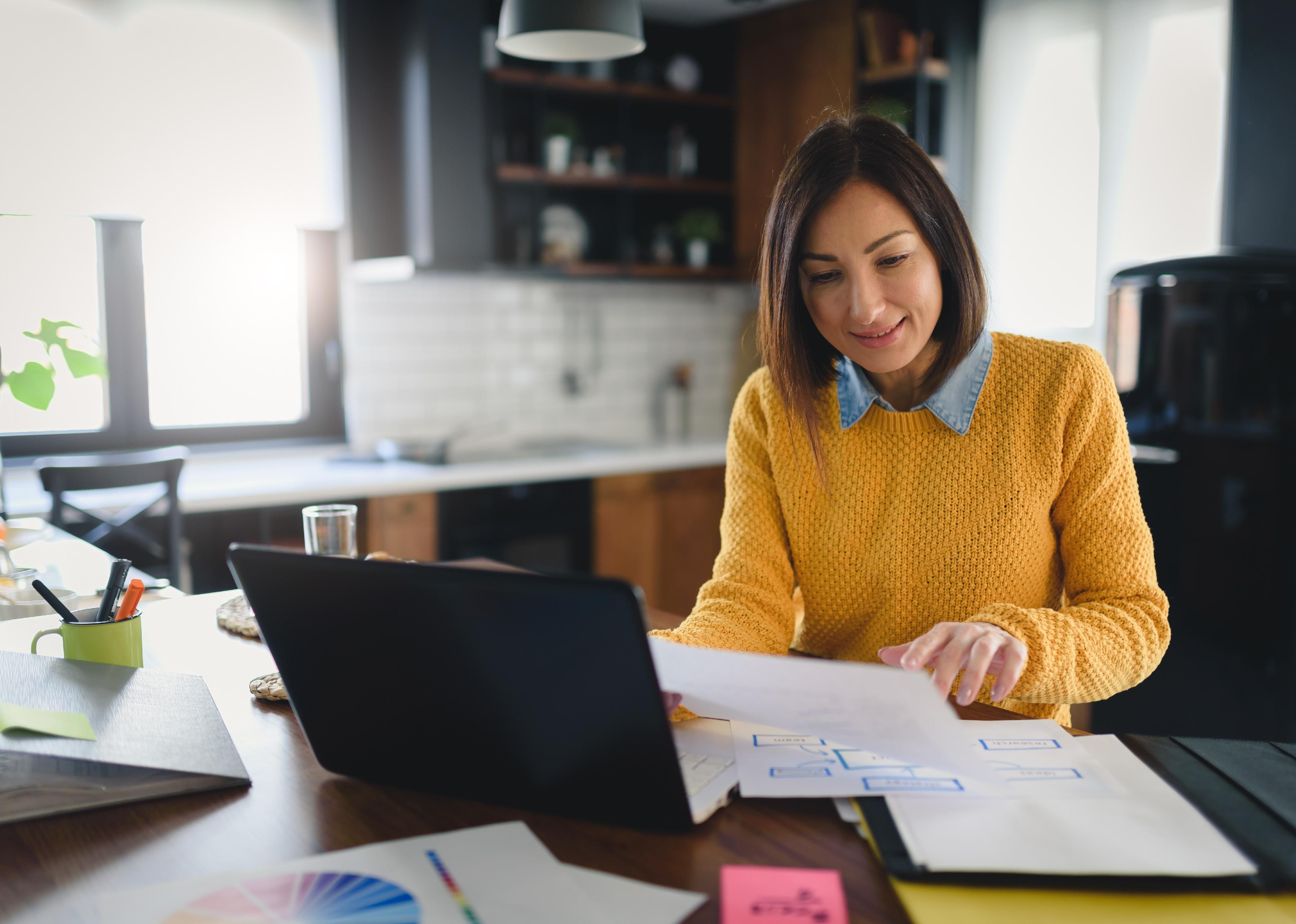 Young businesswoman working at home while having breakfast.