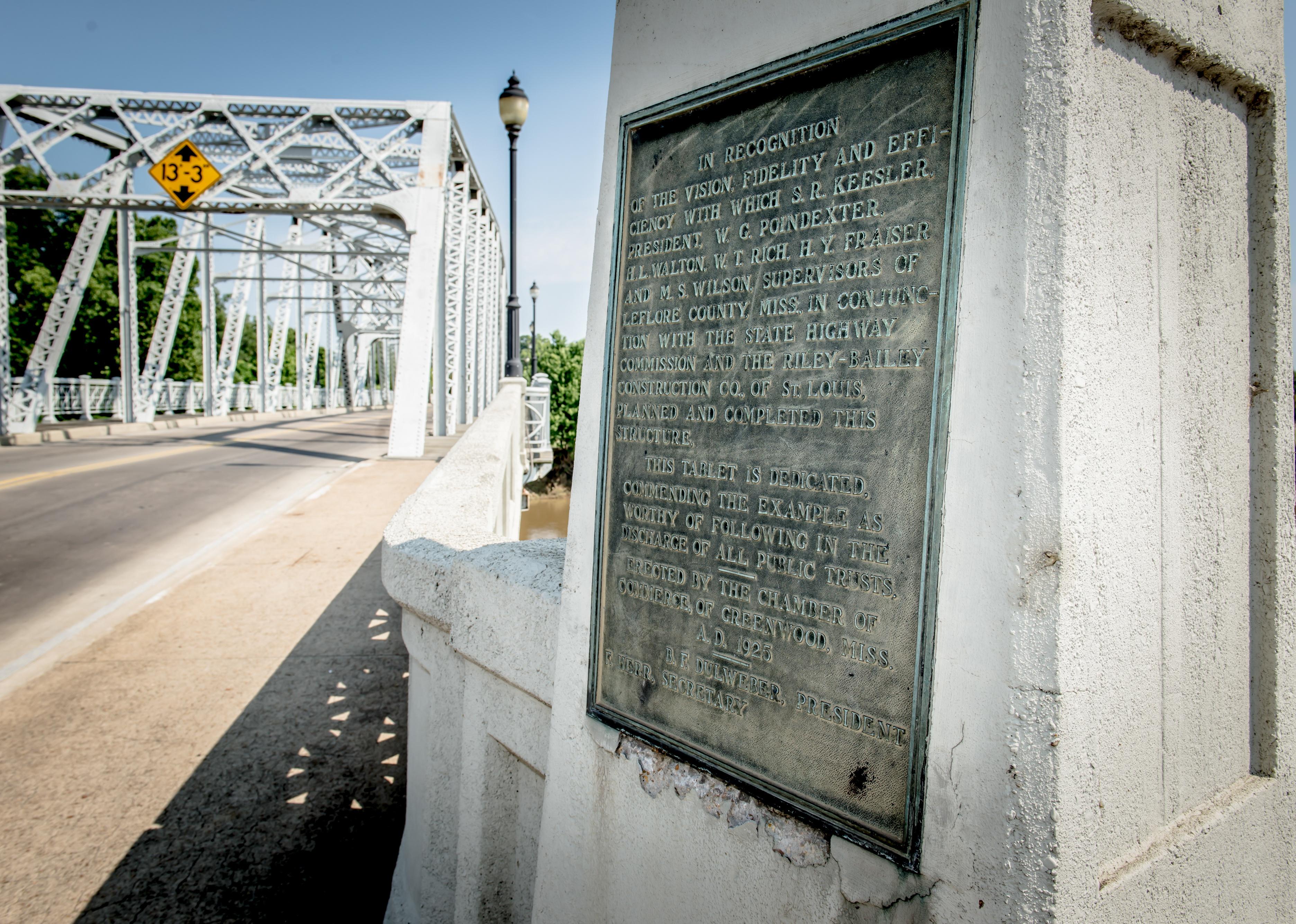 A plaque next to a bridge in Greenwood, Mississippi.