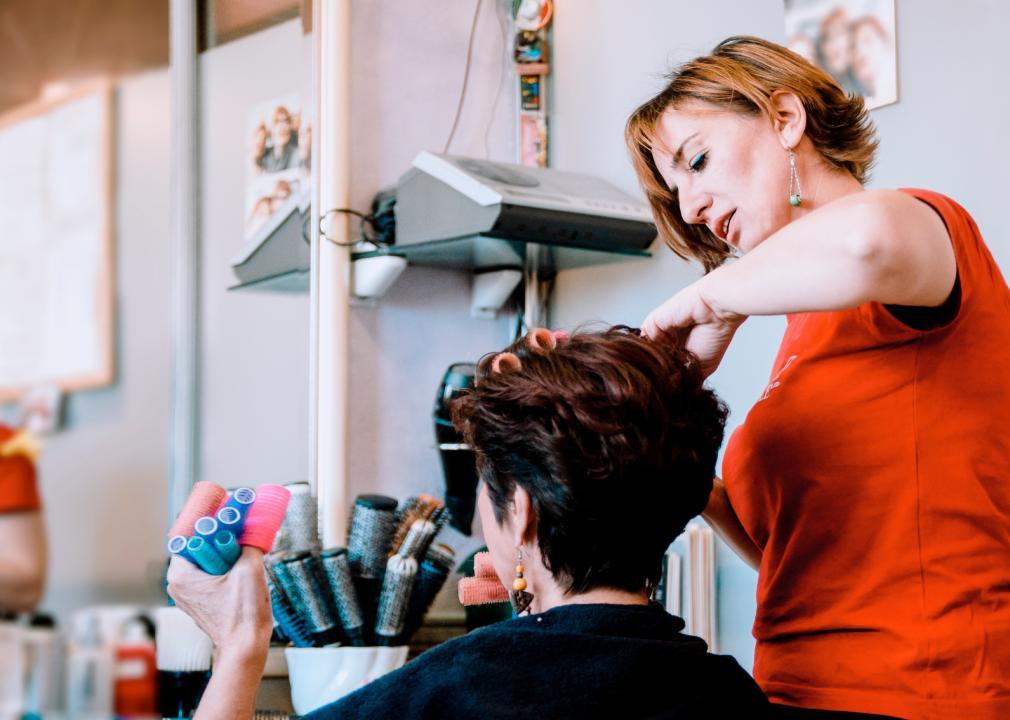 A hairdresser works on a client.