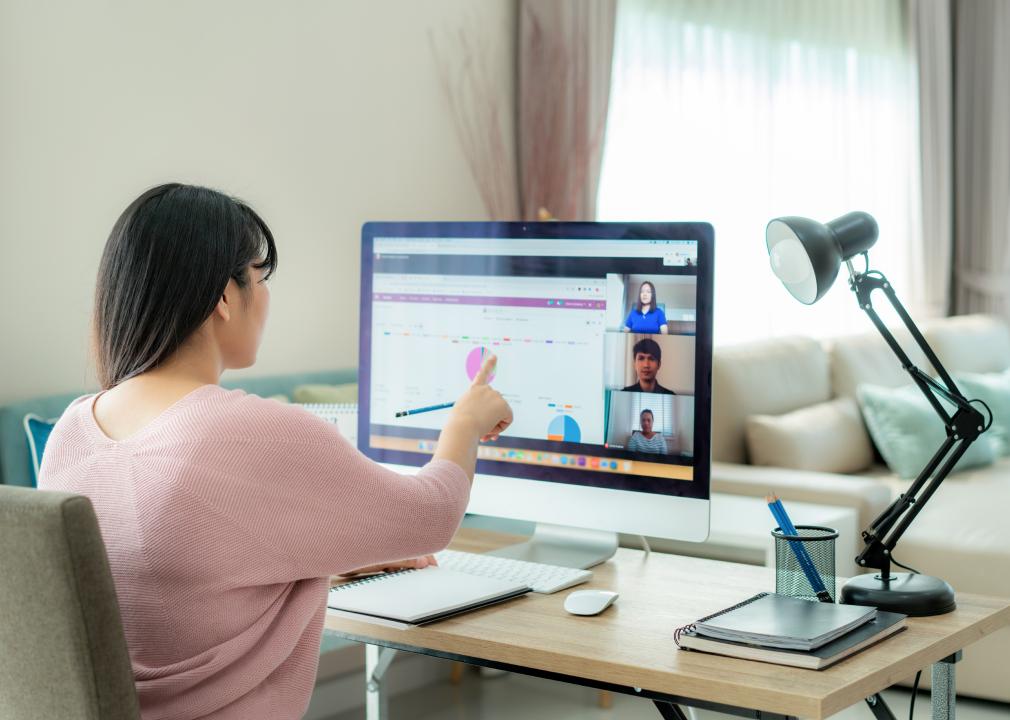 Woman talking to her colleagues on video call with data on screen