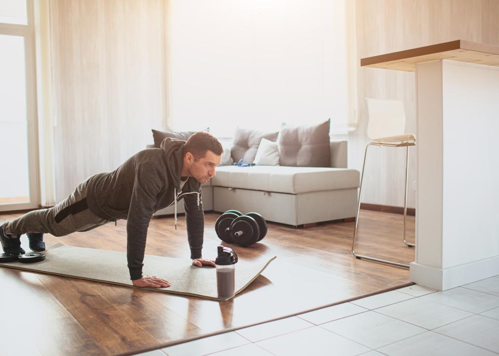 Man in plank position alone in living room.