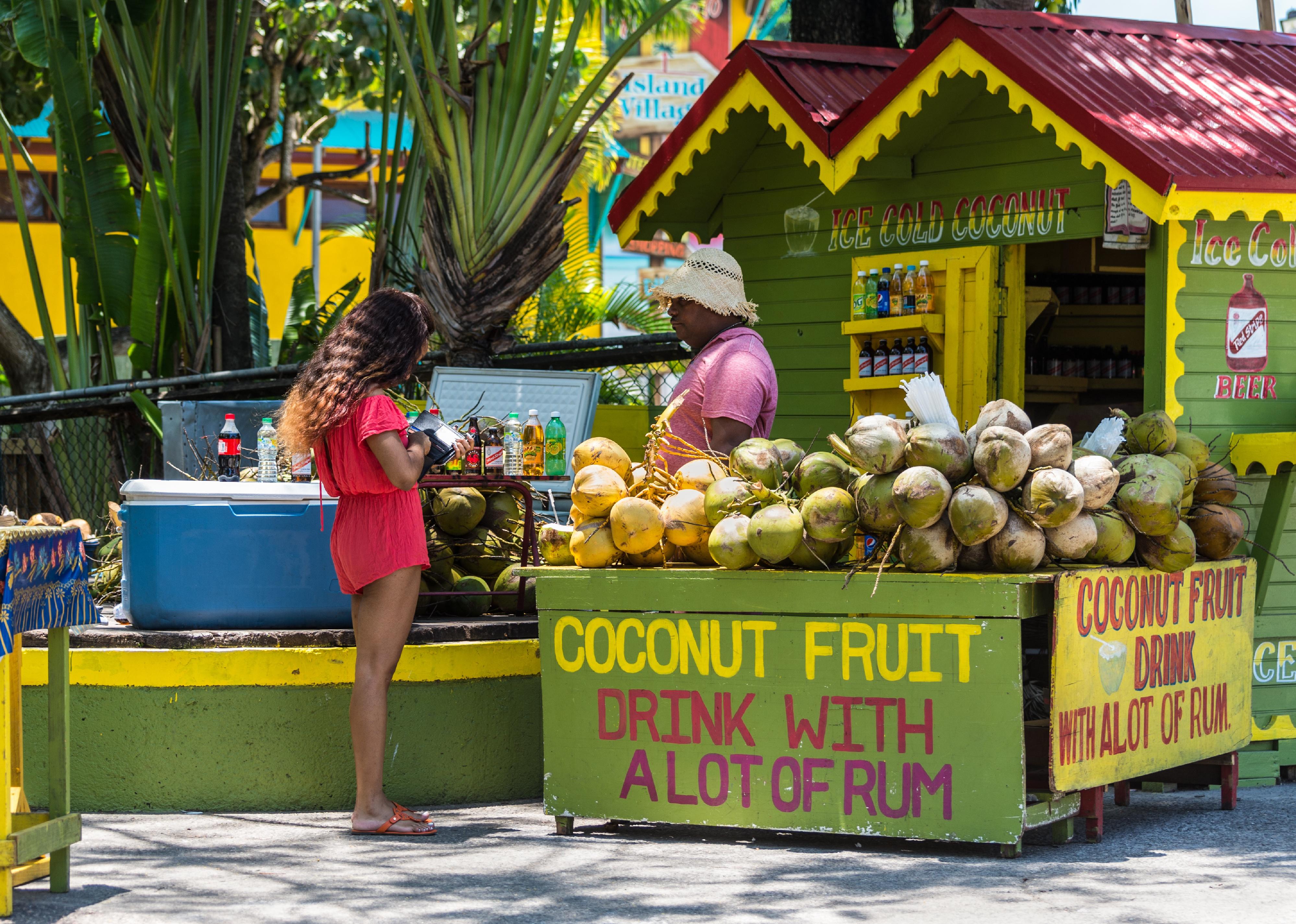 Woman buying a drink at a corner shop in Jamaica.