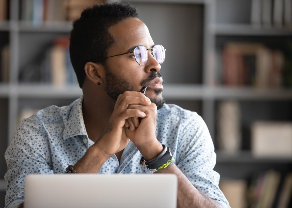 Man in glasses distracted from computer work.