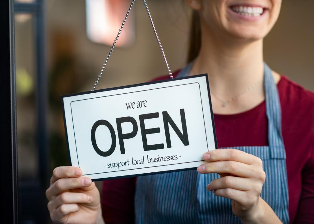 Small business owner smiling while turning the open sign