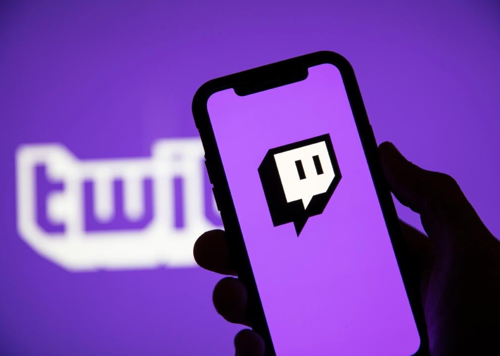 Close-up of person holding phone showing Twitch app.
