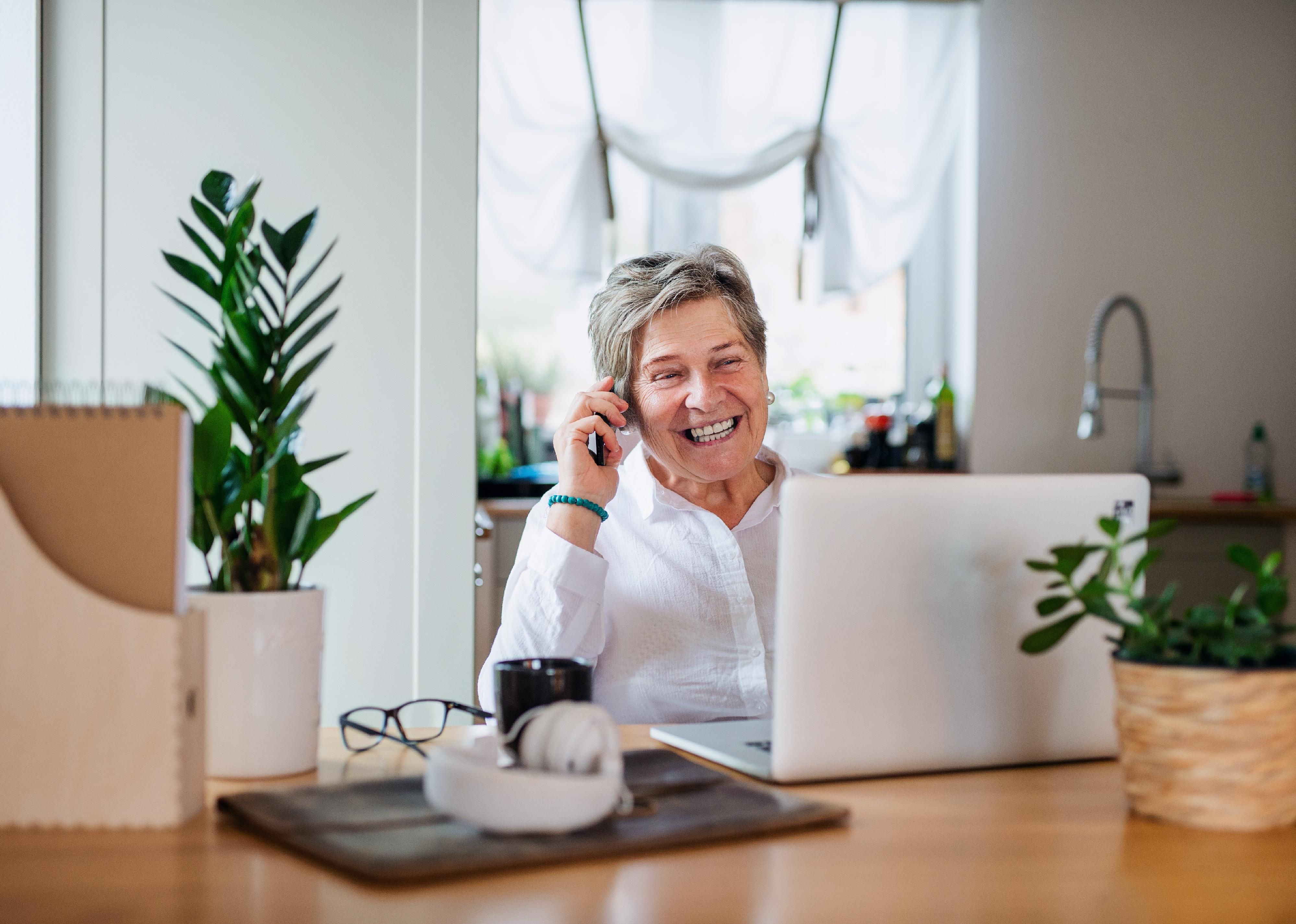 Senior with laptop and smartphone.