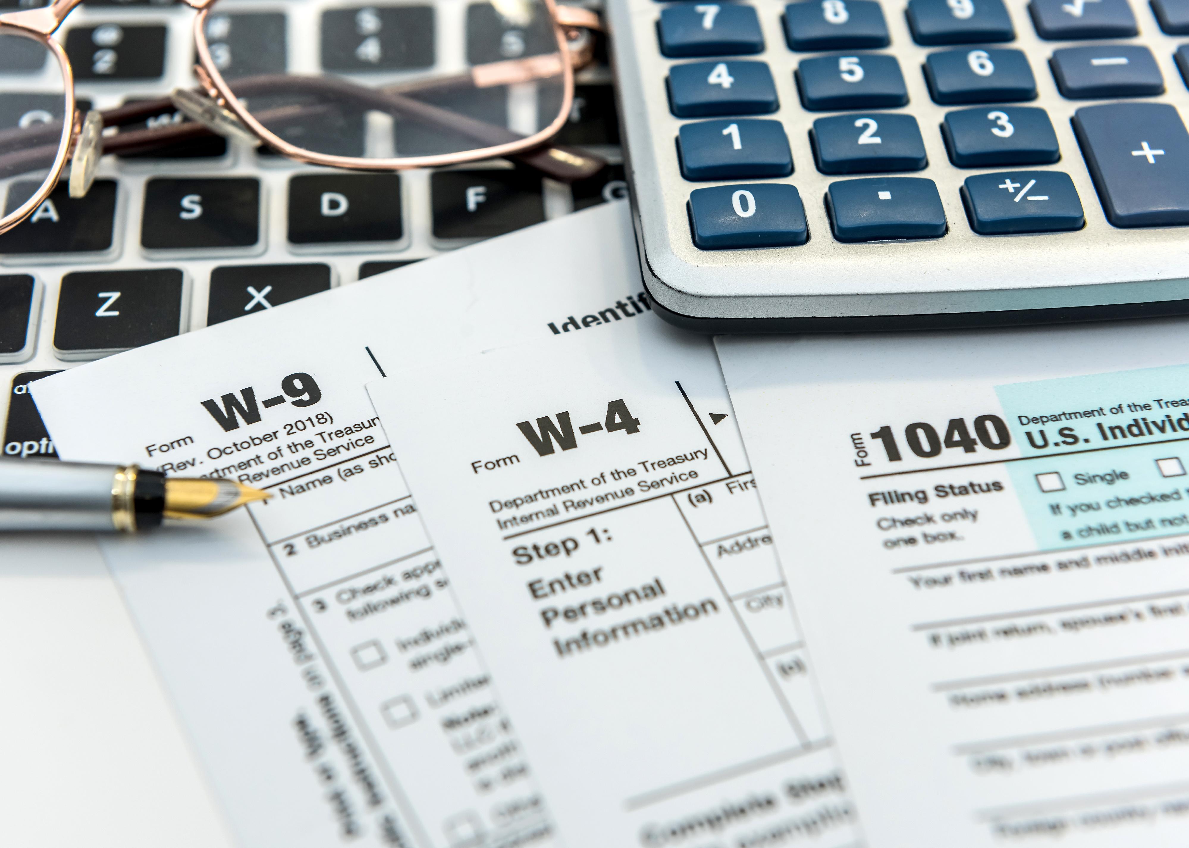 Financial tax form with laptop and calculator.