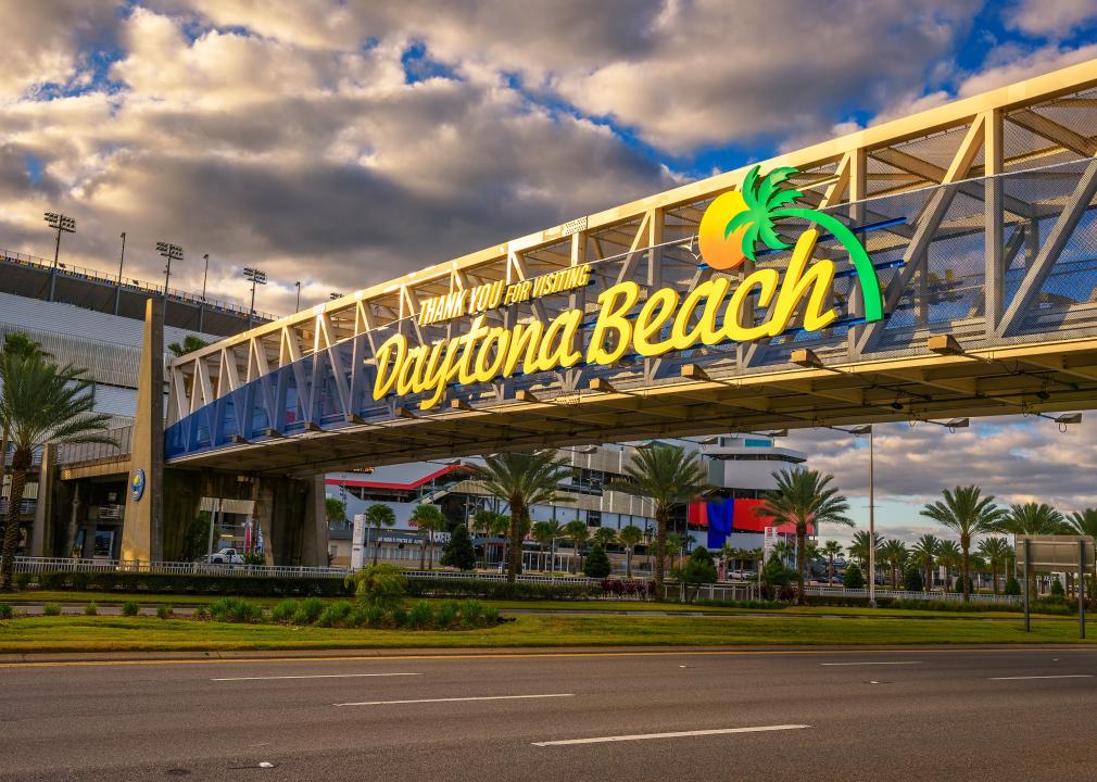 A sign on an elevated catwalk going over a street that reads, Thank you for visiting Daytona Beach.