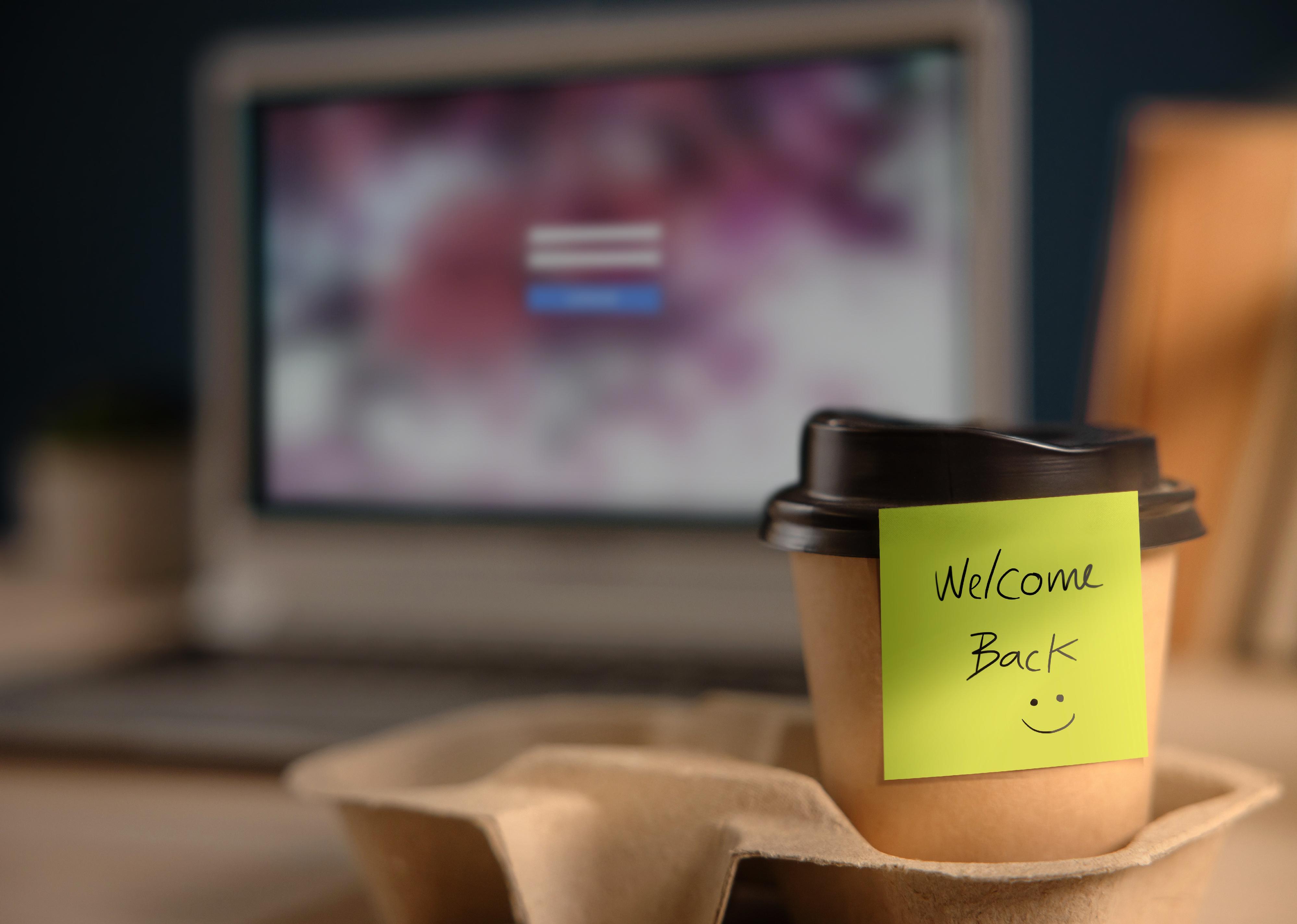 Closeup of Welcome Note on Takeaway Coffee Cup in Office Desk.