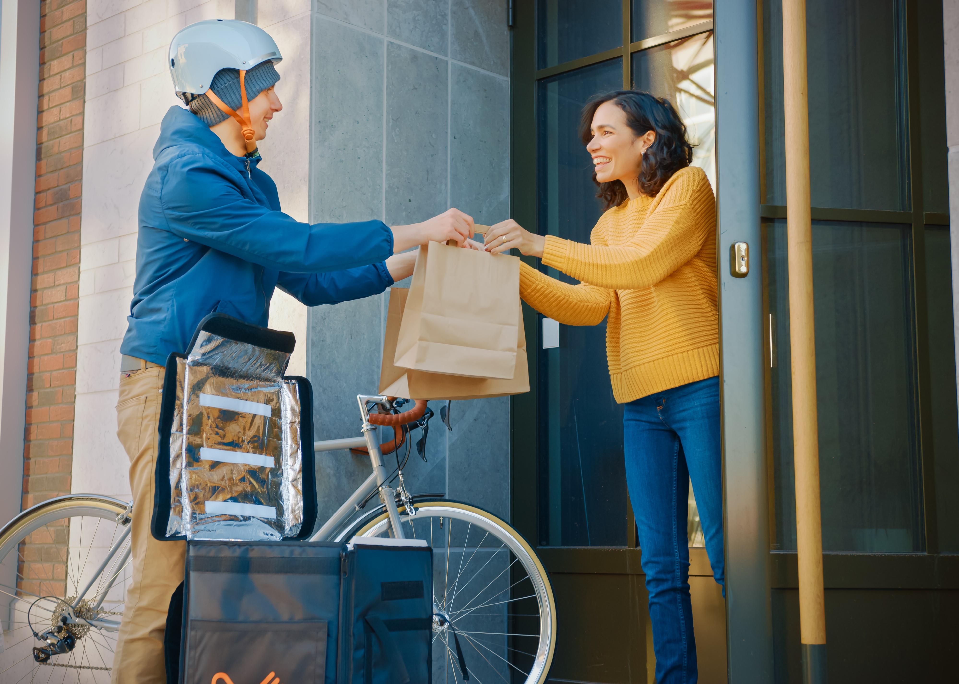 Food delivery man delivers restaurant order to a customer