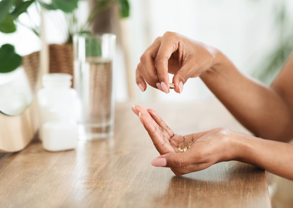 Hands holding supplement pills.