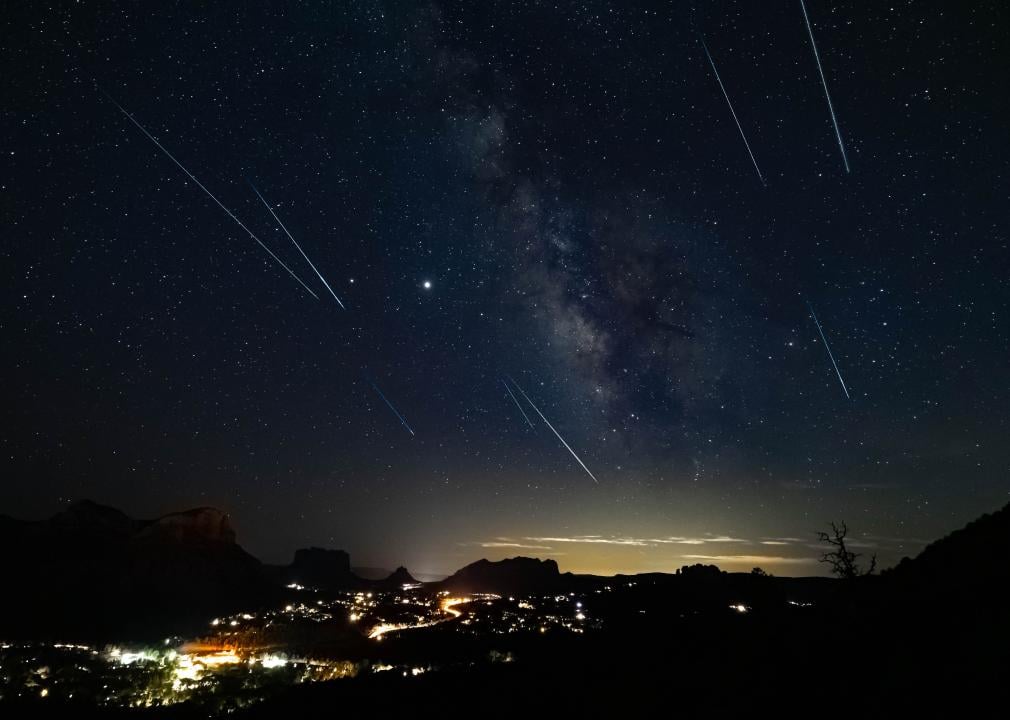 A perseids meteor shower over mountains.