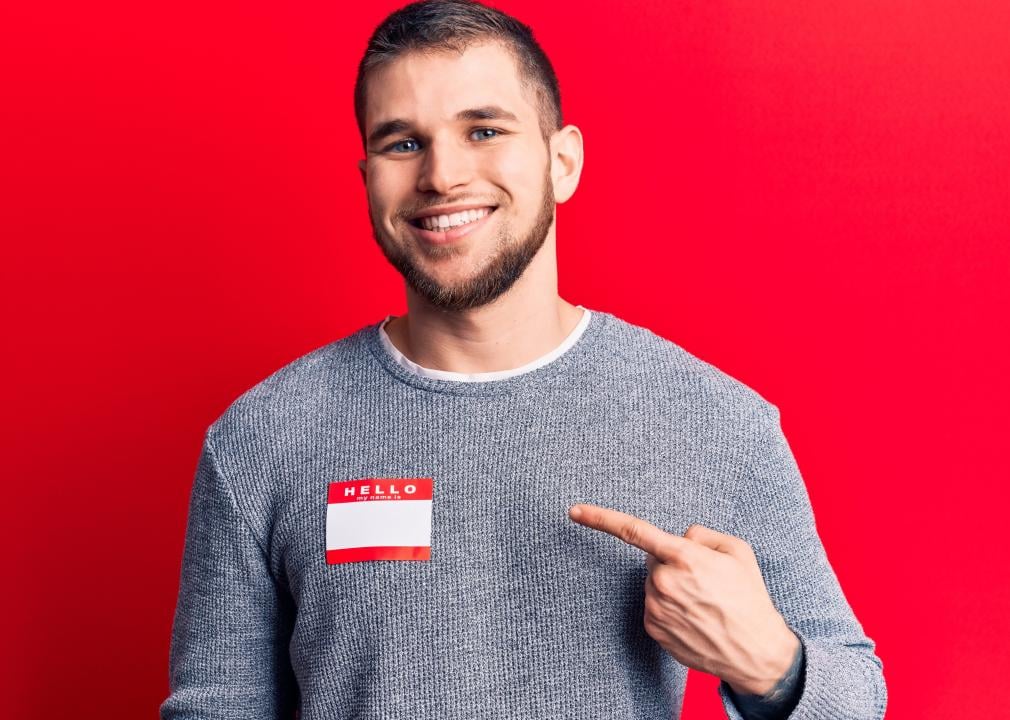 A smiling twenty-something man wearing a hello my name is sticker.