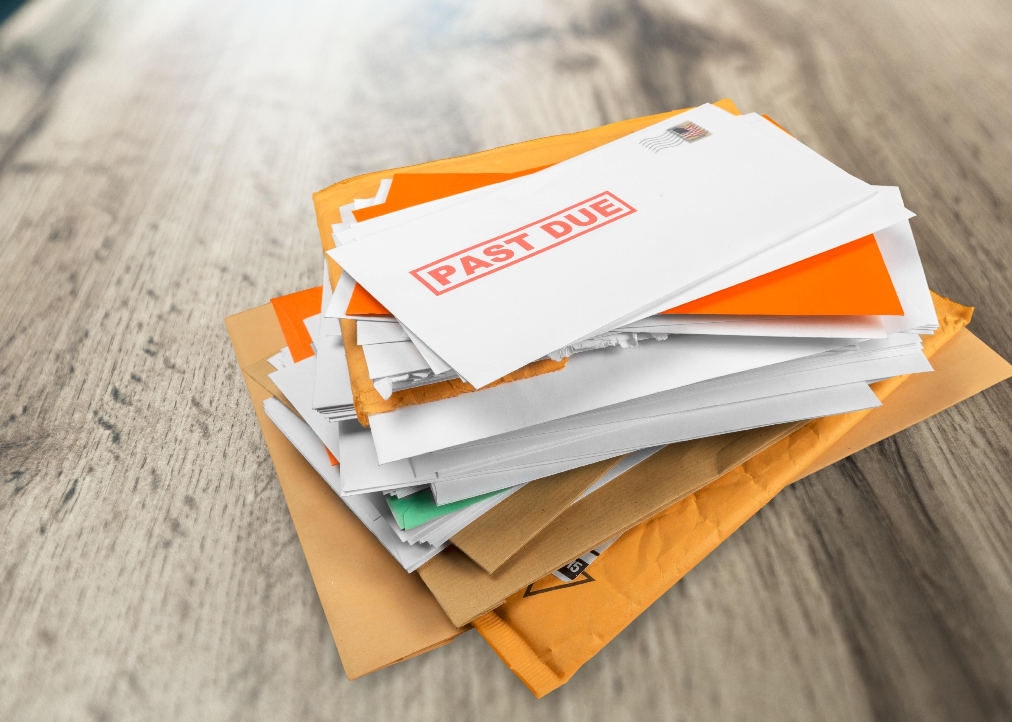 Pile of envelopes with overdue utility bills