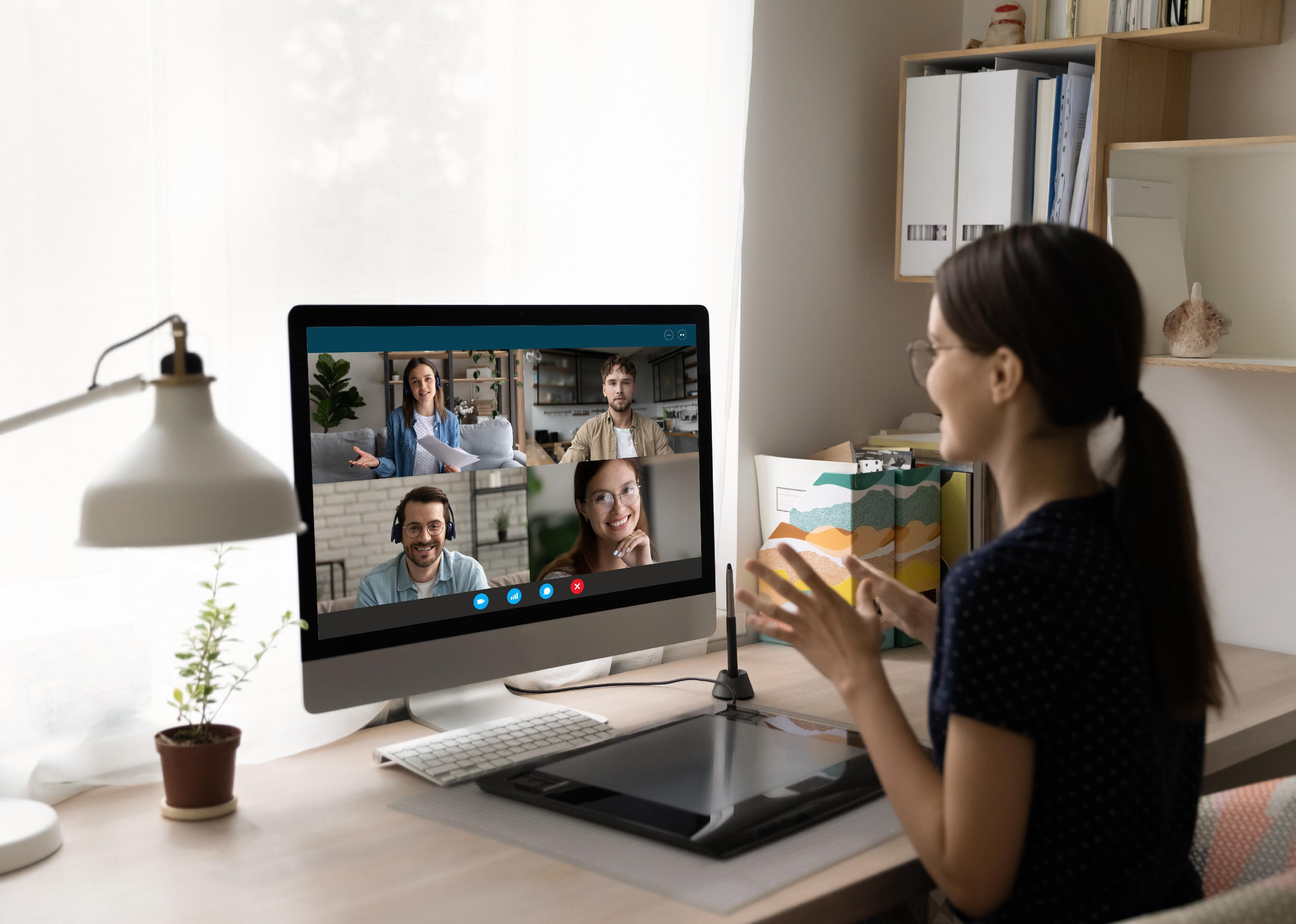 Rear view businesswoman chatting with colleagues online