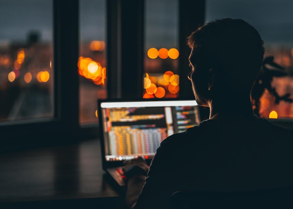 A young male programmer in front of a window