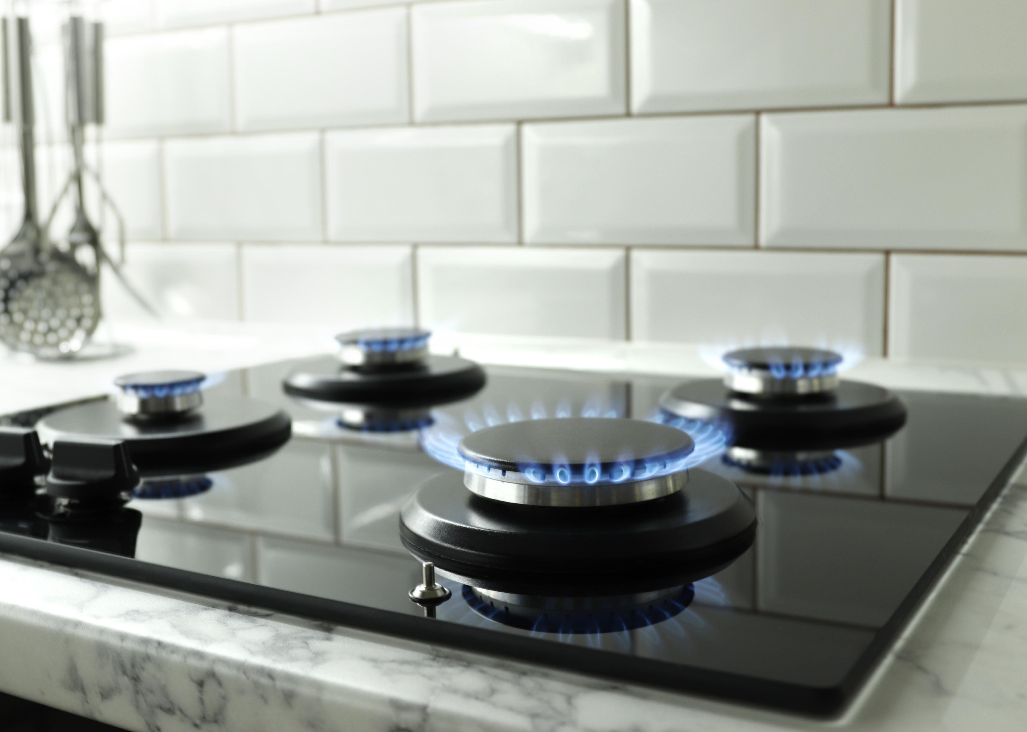 Closeup shot of blue fire from domestic kitchen stove top.