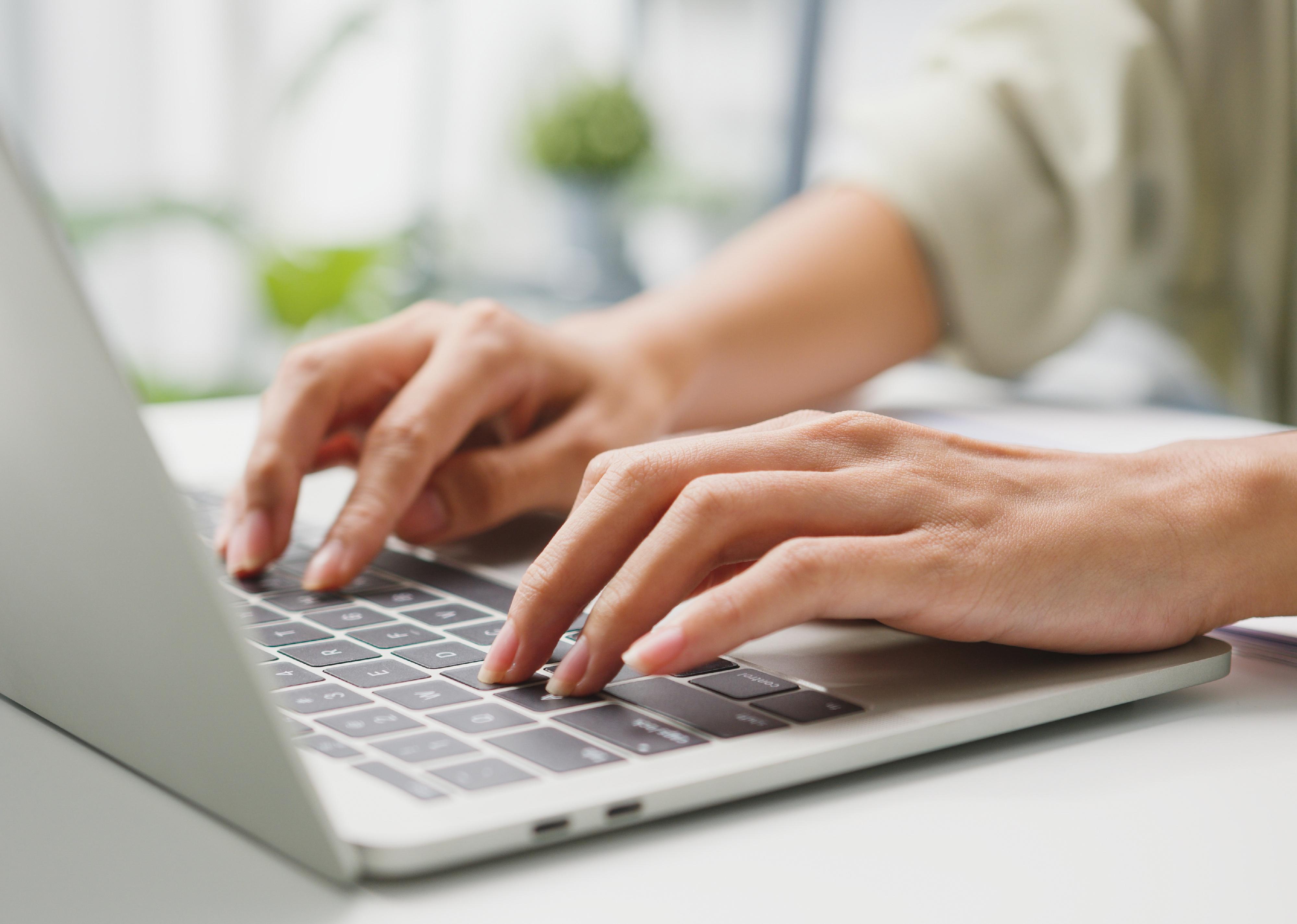 Close-up of two hands on a keyboard