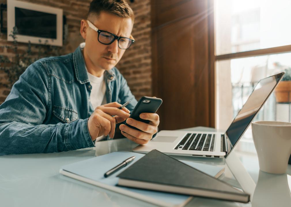 Man pointing on smartphone screen.