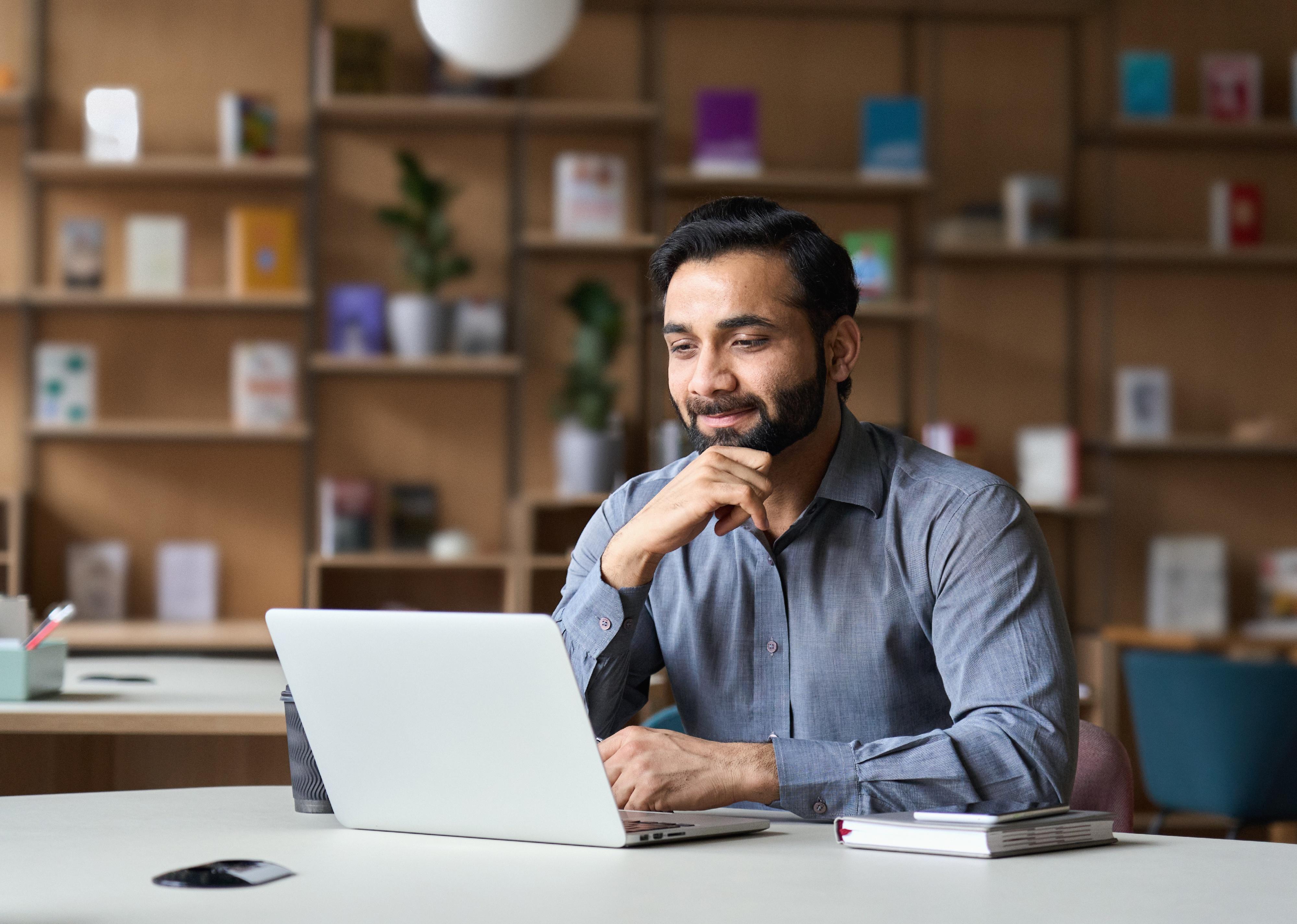 Smiling businessman working on laptop