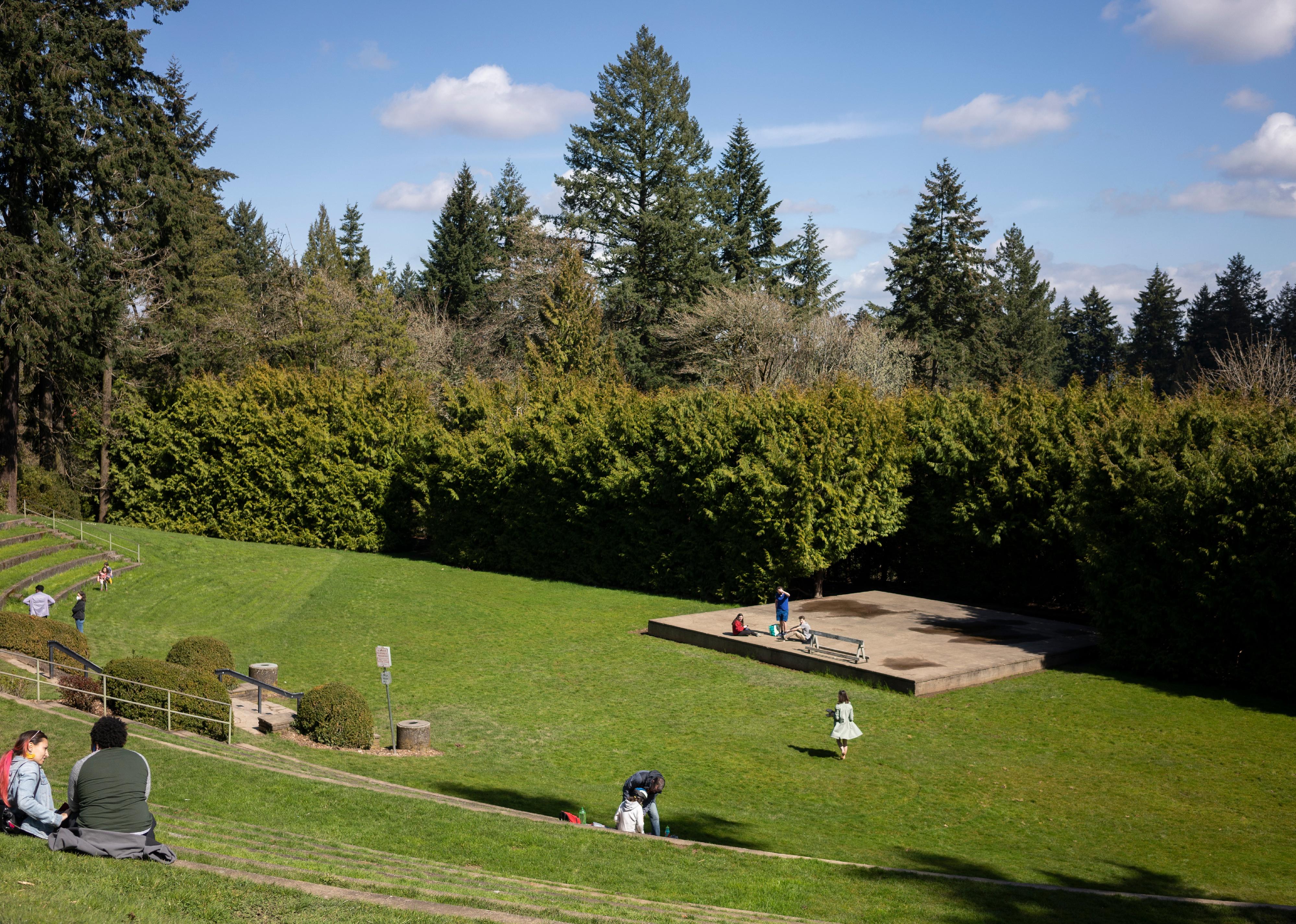 Visitors to the Washington Park amphitheater in Portland seated on the grass.