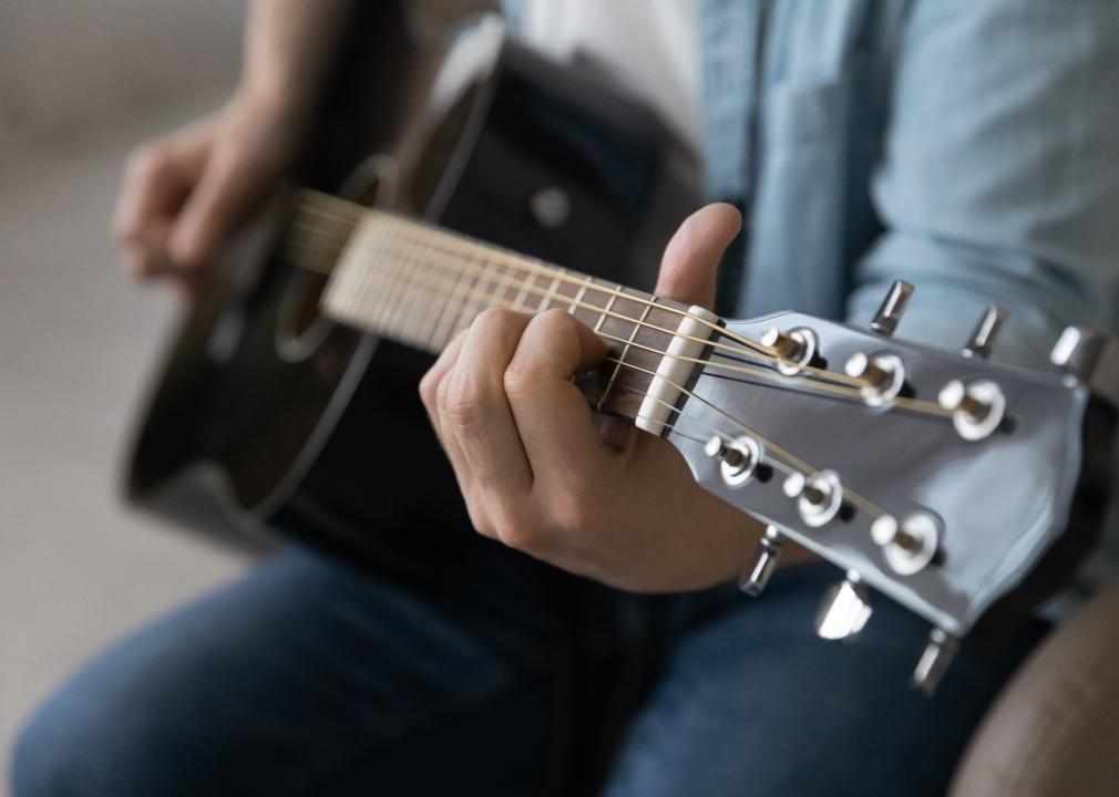 Close up man playing acoustic guitar