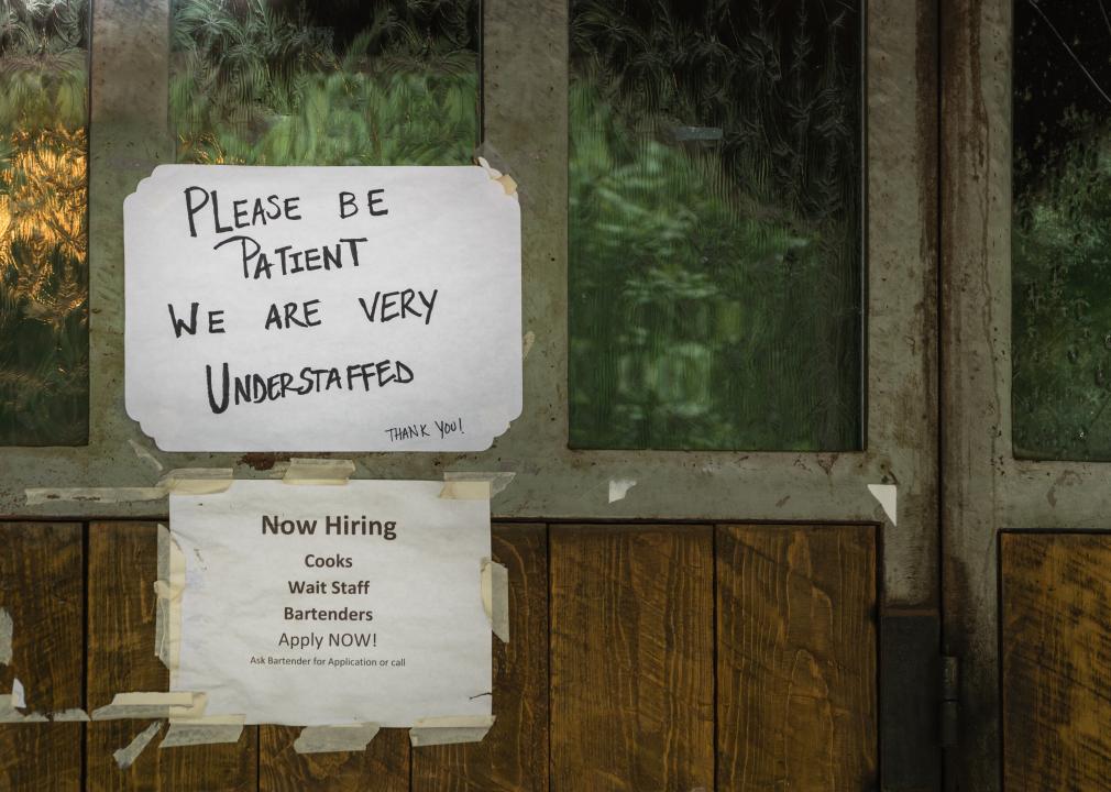 Rustic sign in restaurant stating restaurant is understaffed and hiring.